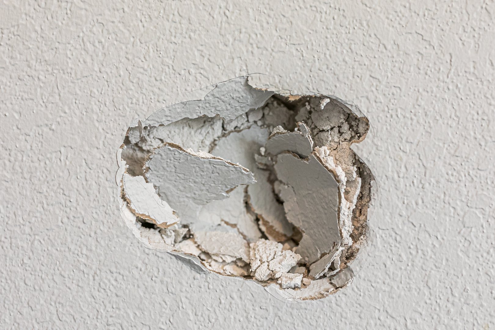 Before and after drywall repair showing a hole in the wall being professionally patched and finished