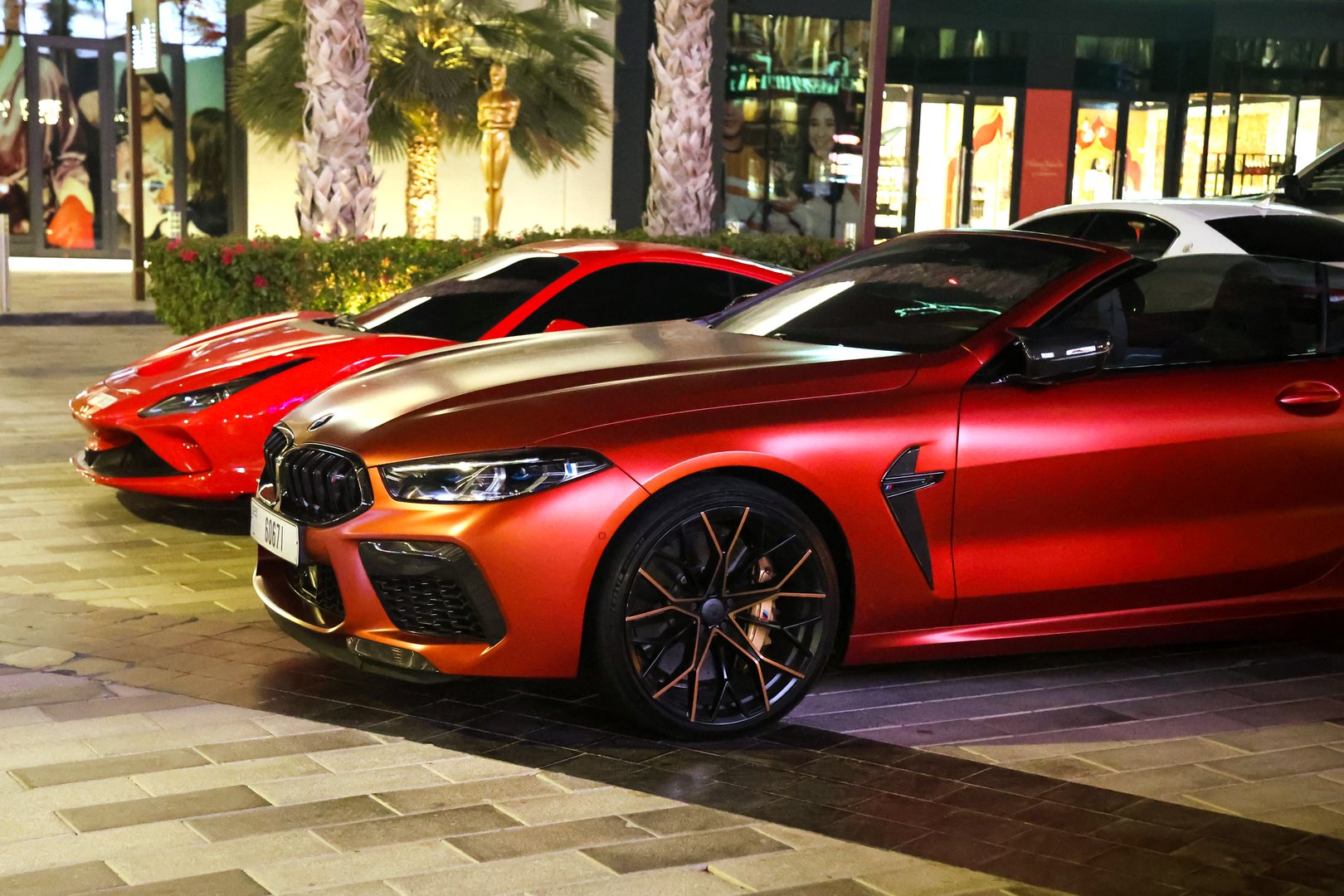 Dubai, UAE - September 28, 2024 Red Ferrari and BMW cars in the city at night. Editorial.