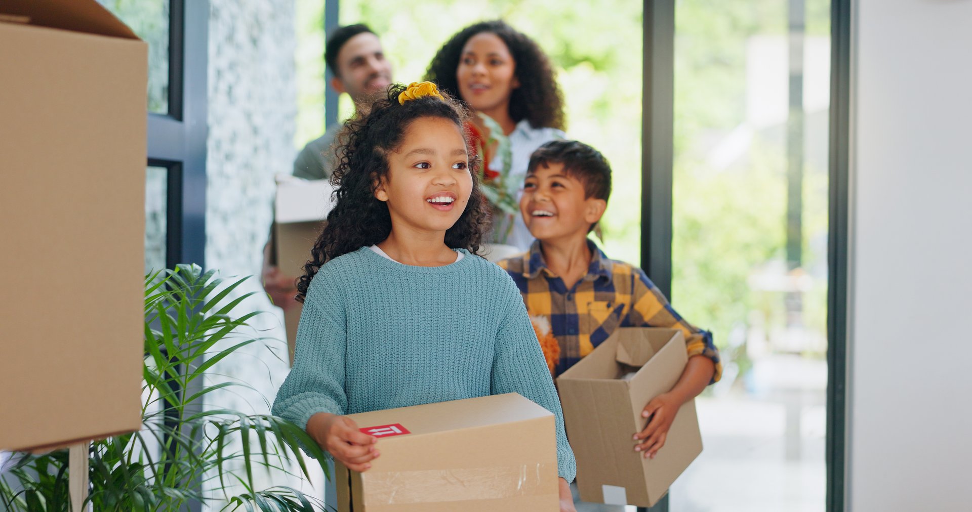 Real estate, parents and children with boxes in new home for property investment, excited and security. Family, people and kids at front door of dream house