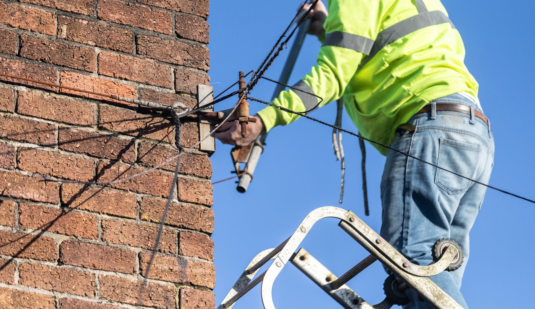 New TV Aerial installed on to an old property chimney - pointing towards the reception area. High level work - blue sky and sun shining.