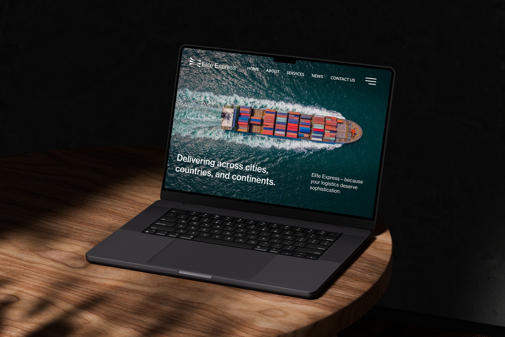 Open laptop on a wooden table displaying a shipping company's website with a cargo ship image.