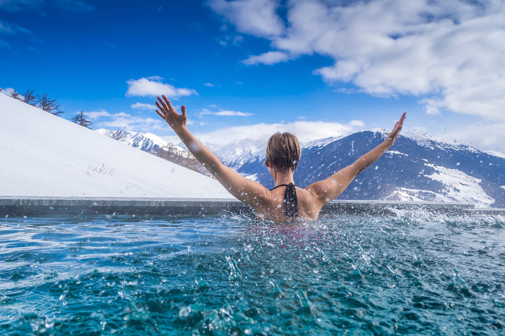 Person in pool with snowy mountains background