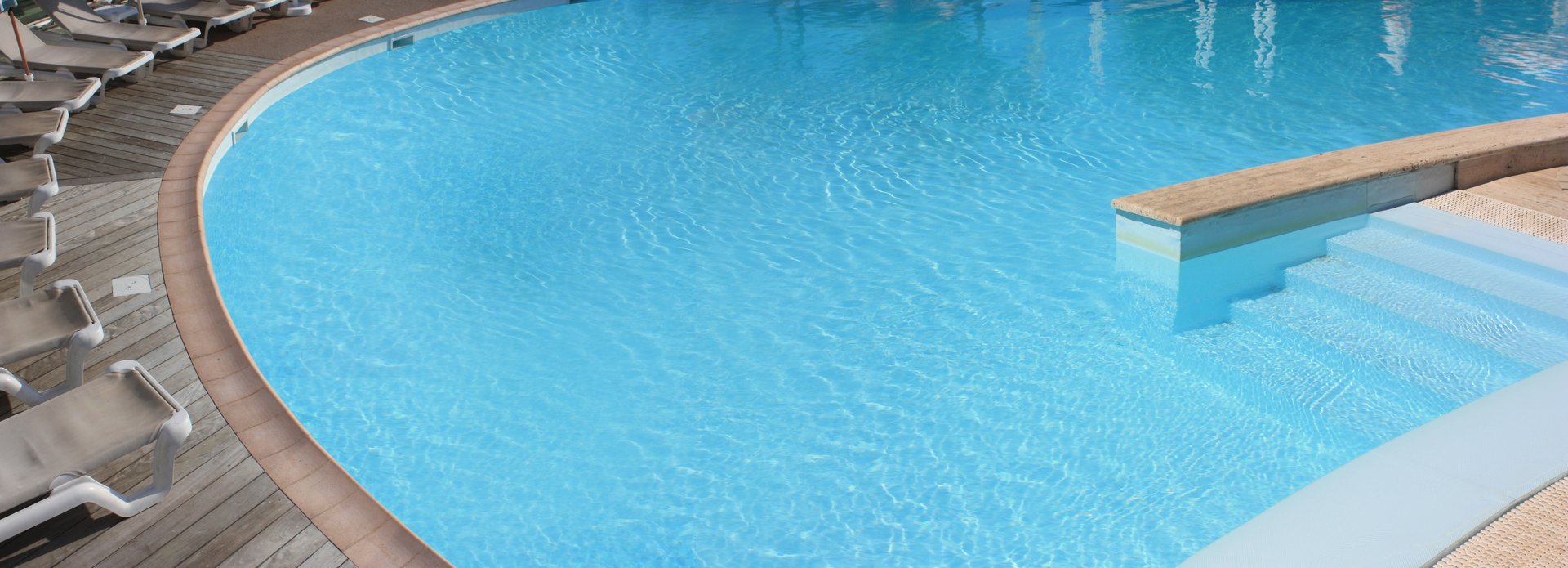 Outdoor swimming pool  Poolside wooden floor  Sun loungers  Holiday resort  Summer season