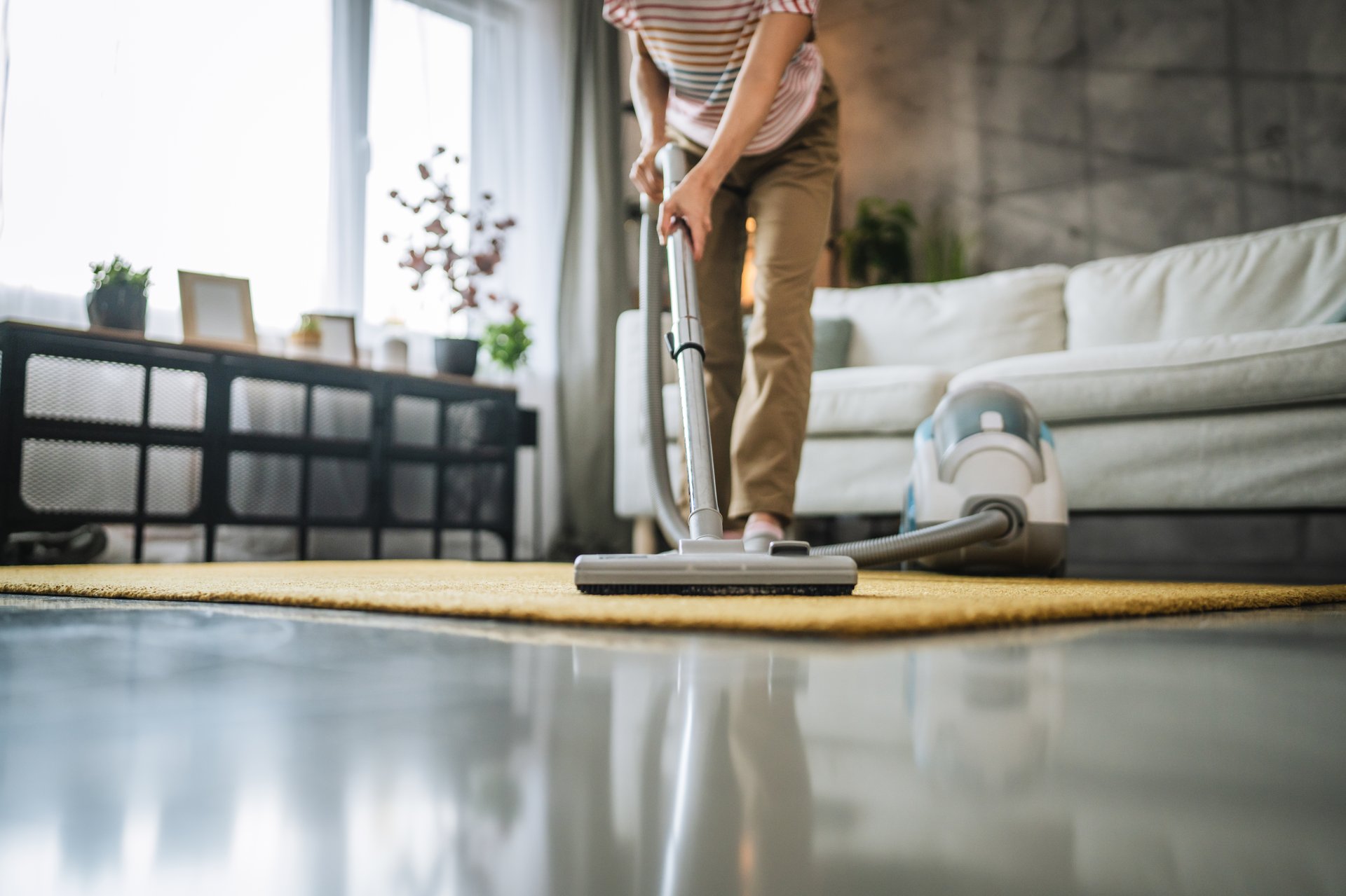 Mature japanese woman vacuums carpet with a vacuum cleaner do housework chores
