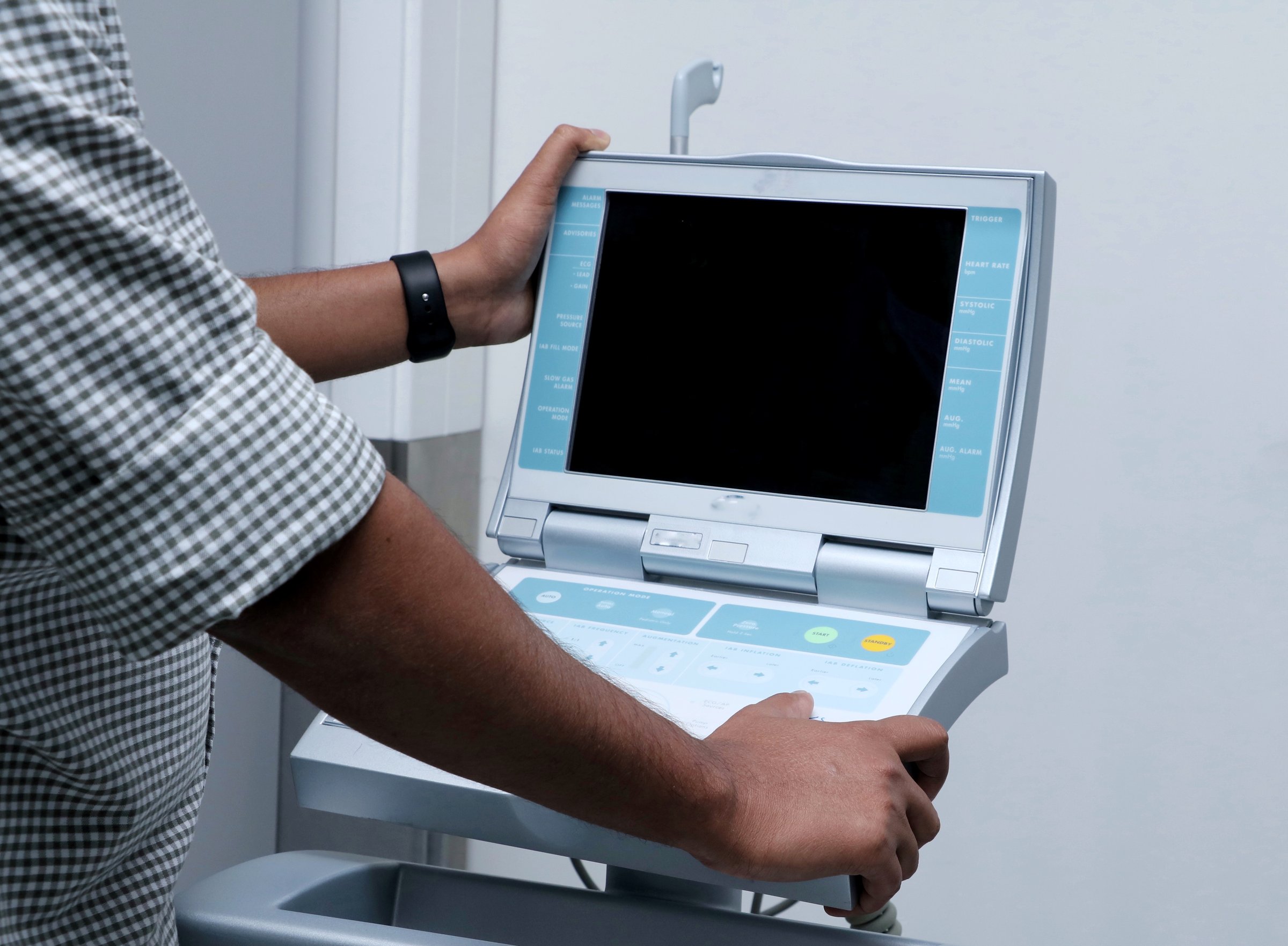 Health care worker operating a intra-aortic balloon pump. machine . An intra-aortic balloon pump (IABP) is a mechanical device that helps the heart pump blood.