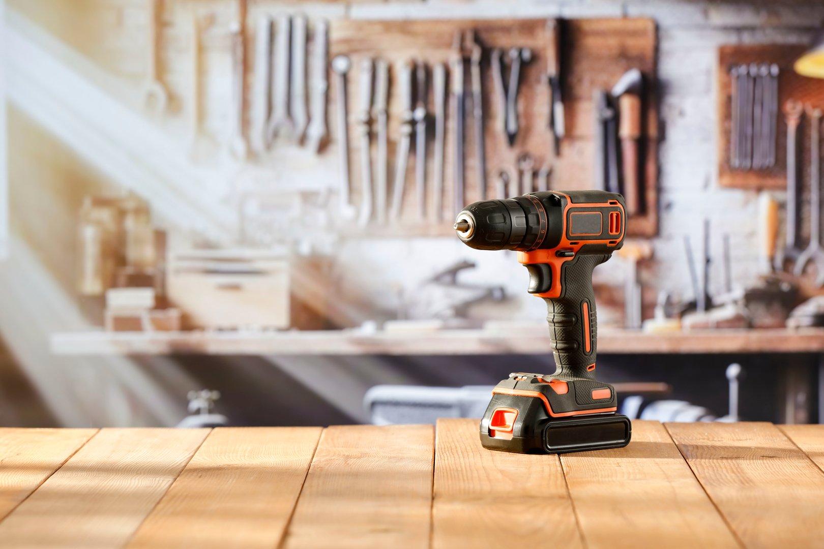 A mechanical cordless screwdriver on a wooden workbench in a craftsman's workshop