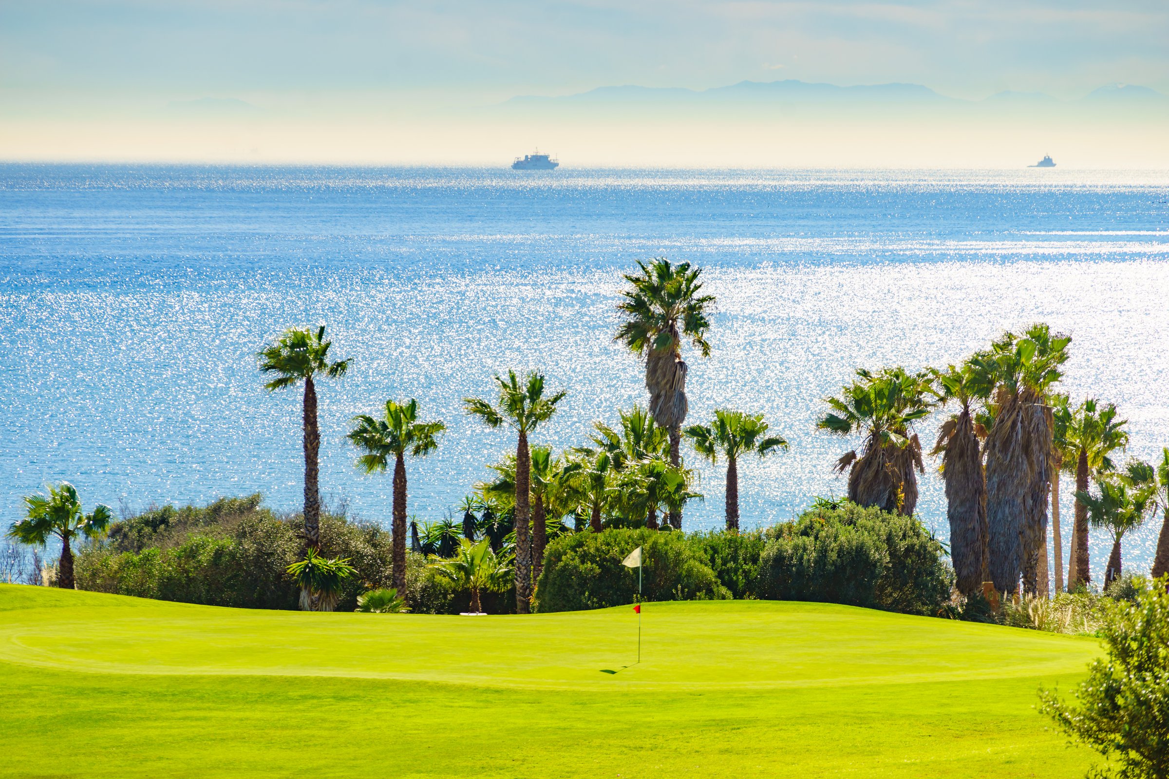 Golf course and palm trees on sea coast, Sotogrande in Andalusia Spain