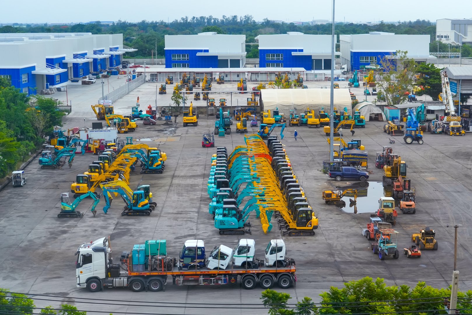 Multiple cars, excavators, bulldozers, tractors, machinery Komatsu, Kobelco, Cat, Hitachi, Doosan, Sany. Thailand, Bangkok. 13 May 2024.