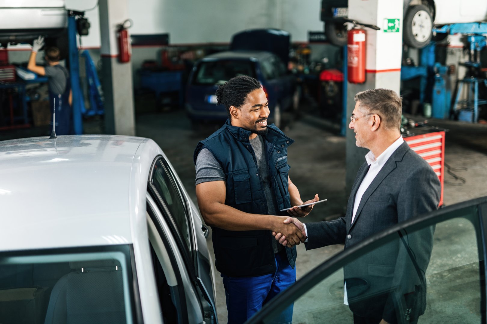 Happy customer shaking hands after car repair