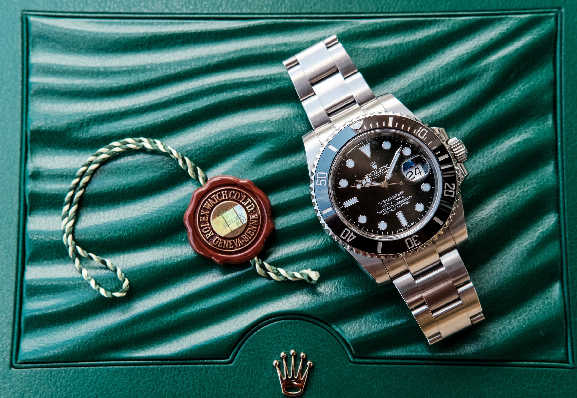 St Ives, Cambridgeshire, UK - May 24 2016: Rolex mechanical divers watch as seen laying on the top surface of the office Rolex presentation case. Notice the gold coloured crown on the front. This model is the Submariner.