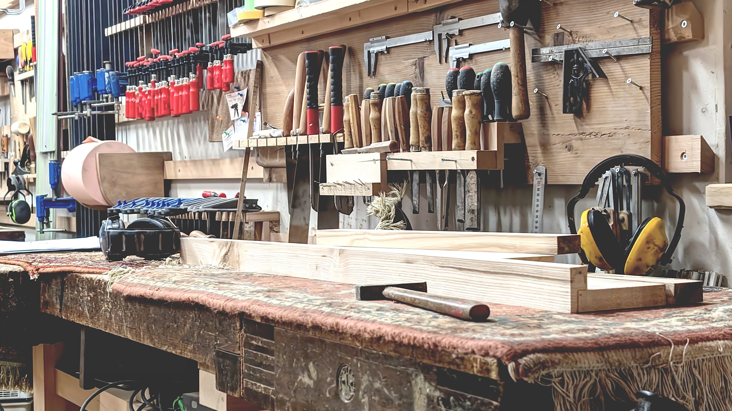 Woodworking tools arranged neatly in a rustic workshop with various hand tools