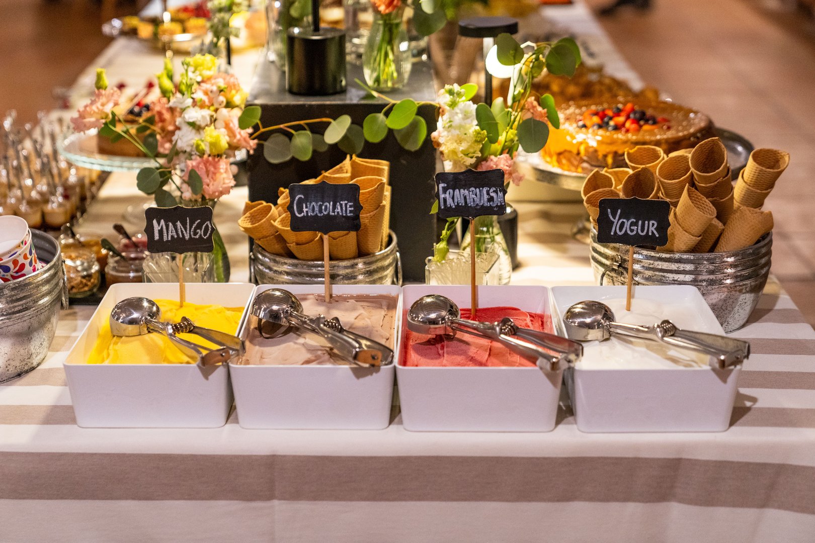 An assortment of colorful ice cream flavors displayed on a buffet table, ready to be served, perfect for celebrations or dessert spreads.