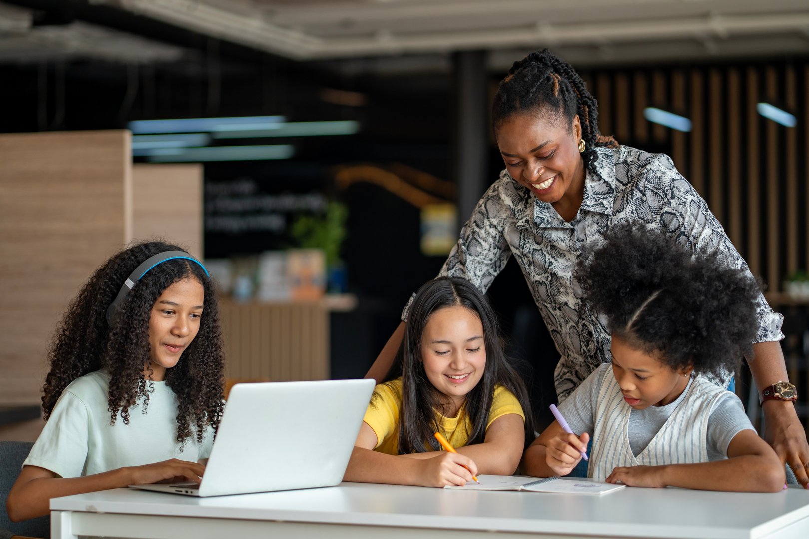 African school teacher is teaching and guiding group of young student in the class using information from experience and internet for academic literacy study and education usage