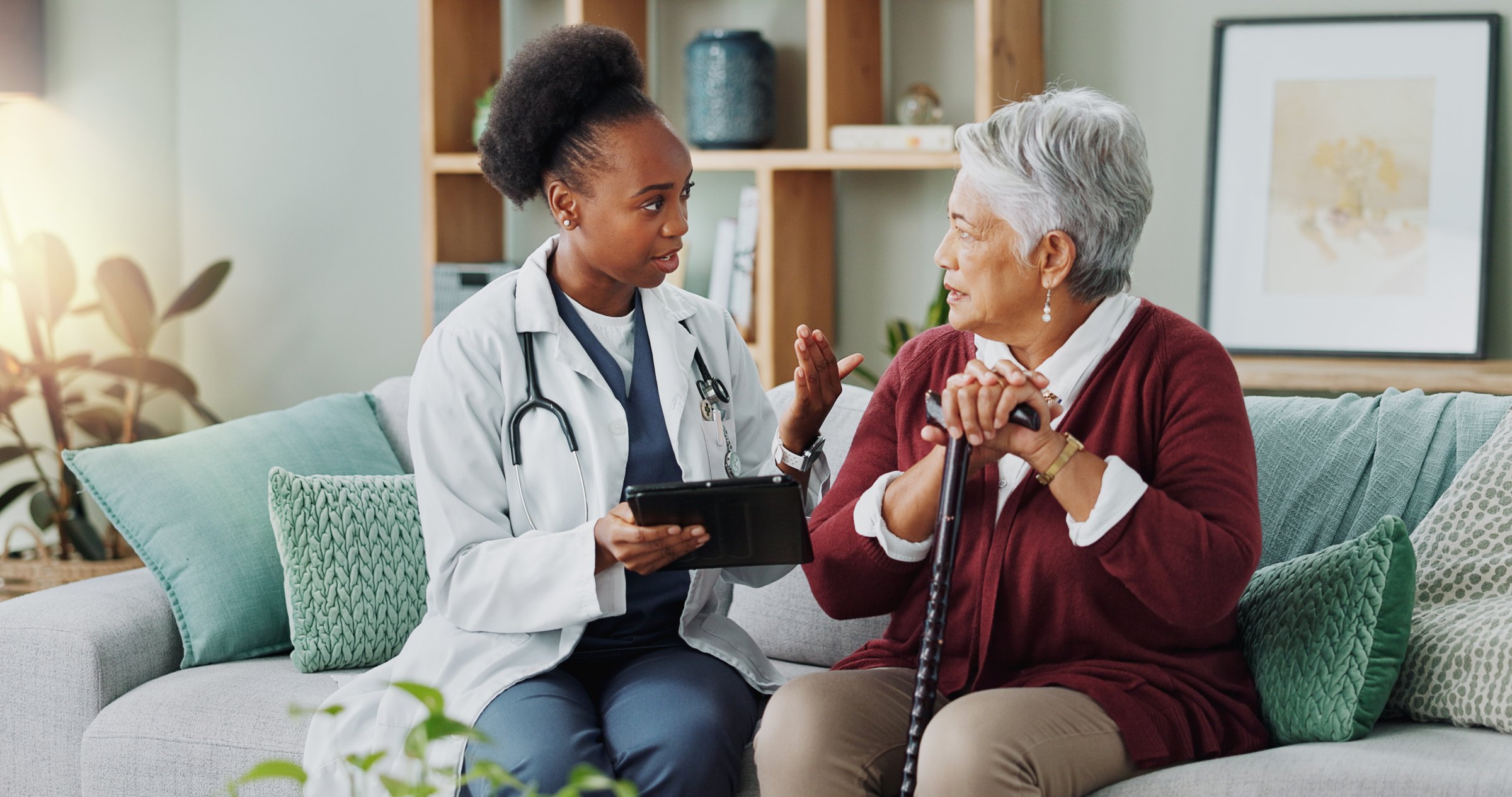 Elderly, woman and doctor with tablet for consultation with expert advice, explaining and healthcare support. Senior patient, nurse and discussion in nursing home, medical diagnosis and assessment