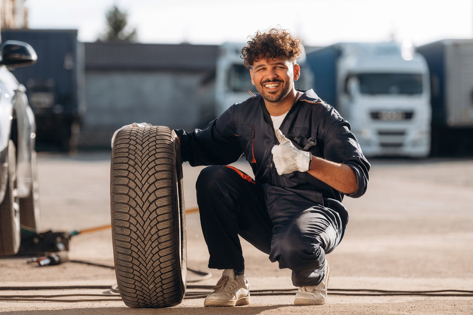 Outdoors with new tire. Mechanic is with the car.