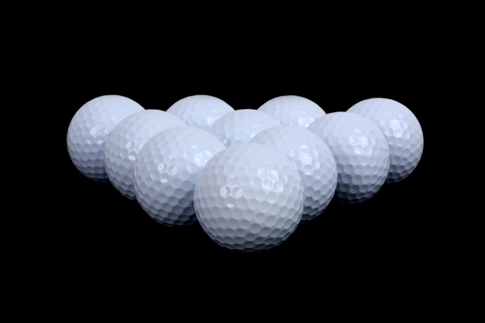 rows of golf balls on black background sport concept