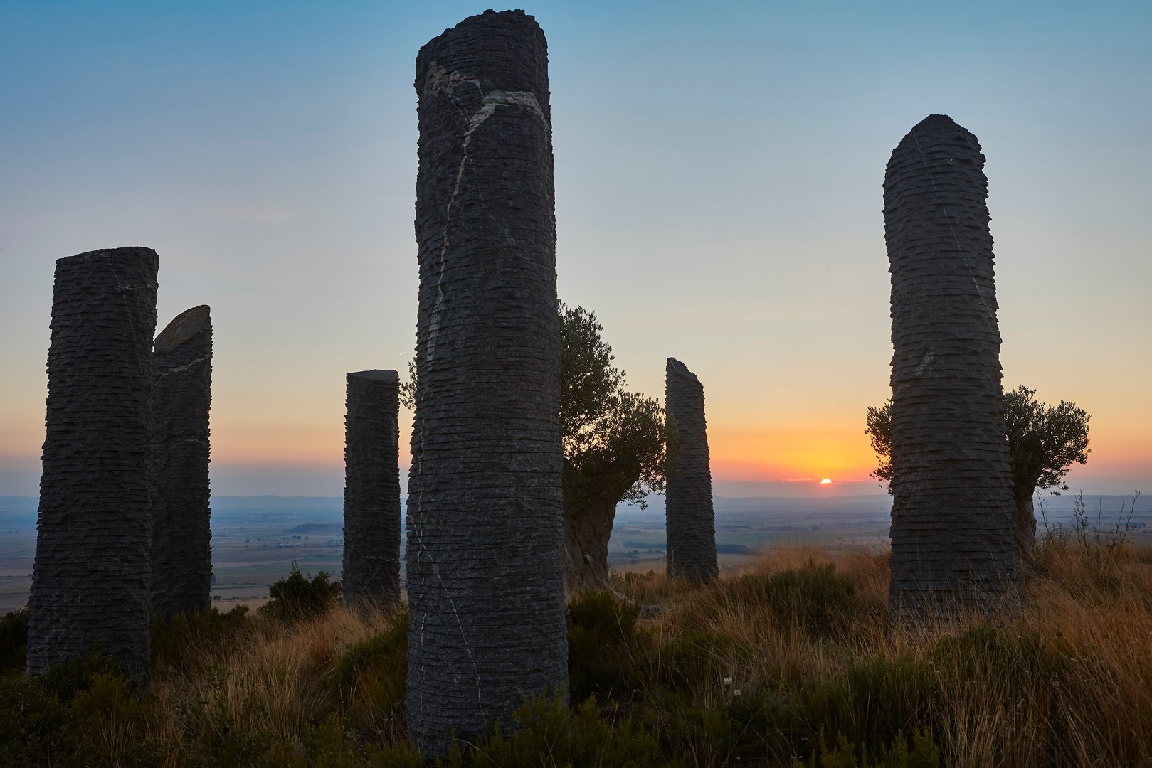 Granite monolith sculptures at sunset representing strength and permanence