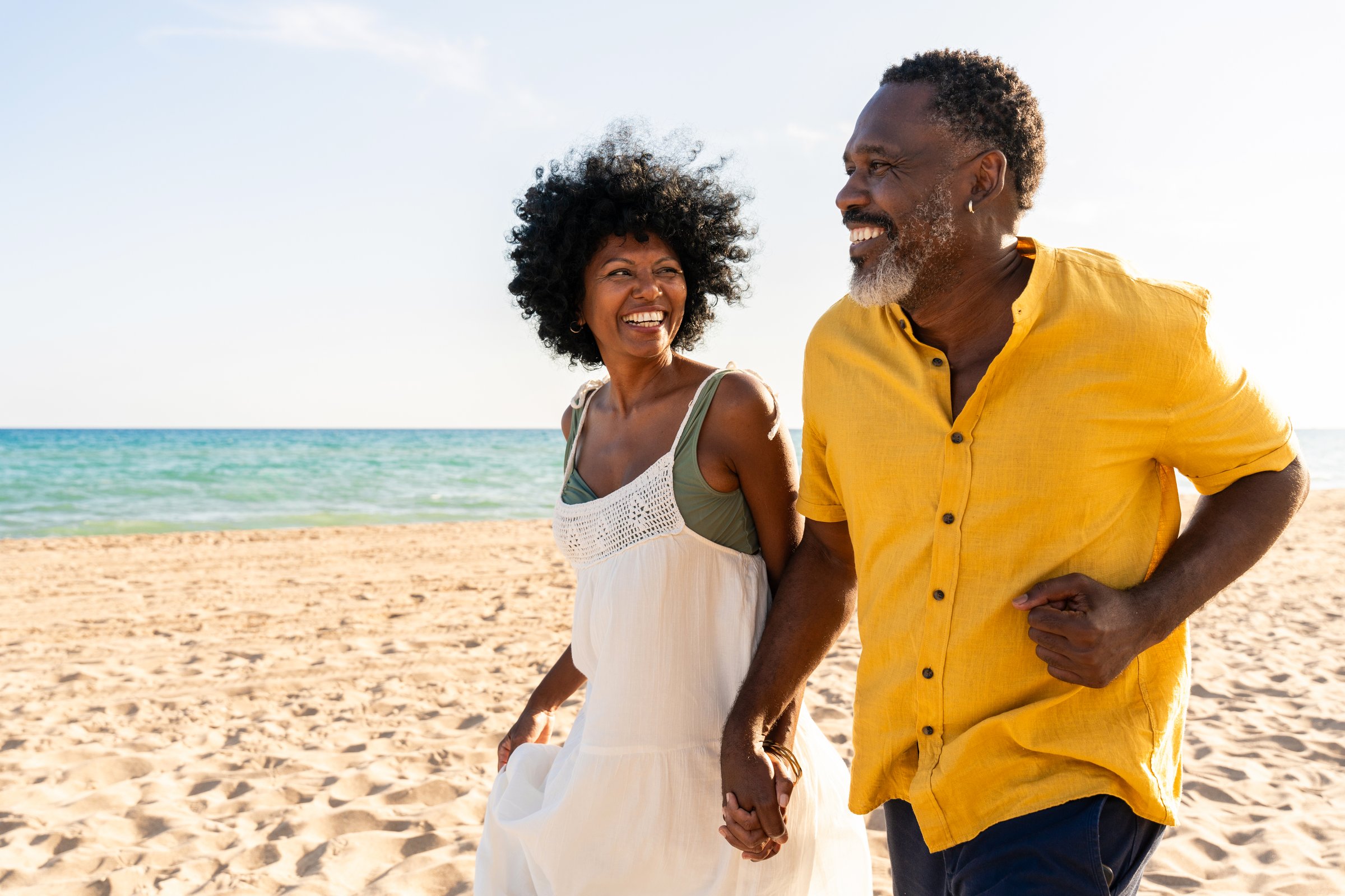 Beautiful mature black couple of lovers dating at the seaside - Married african middle-aged couple bonding and having fun outdoors, concepts about relationship, lifestyle and quality of life