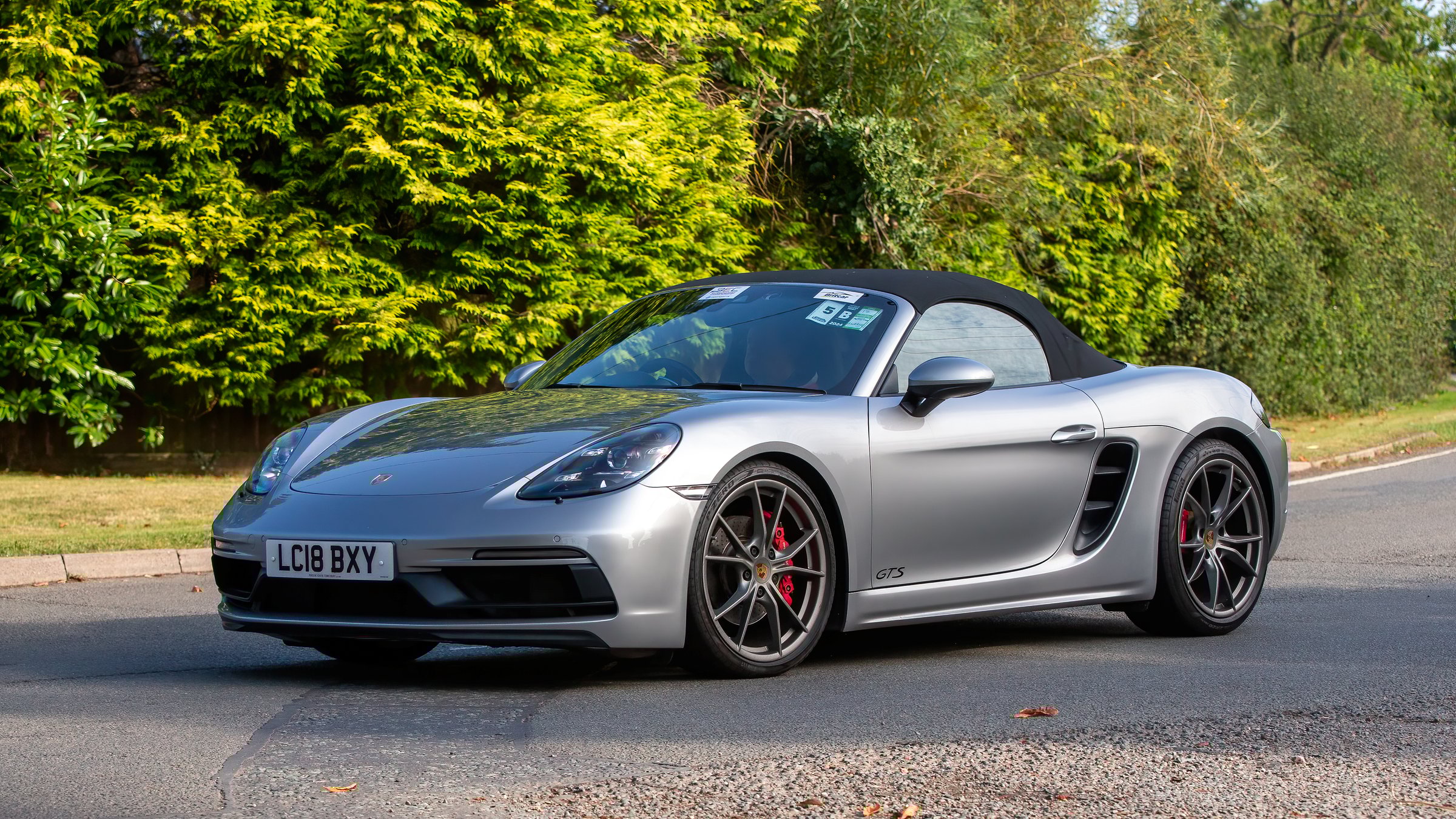 Whittlebury,Northants.,UK - Aug 25th 2024: 2018 silver Porsche Boxster car driving on a British country road.