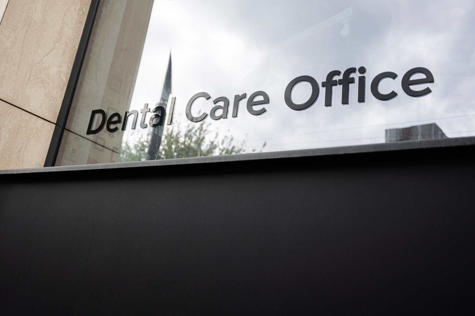Modern dental care office with exterior reflective glass windows and visible signage