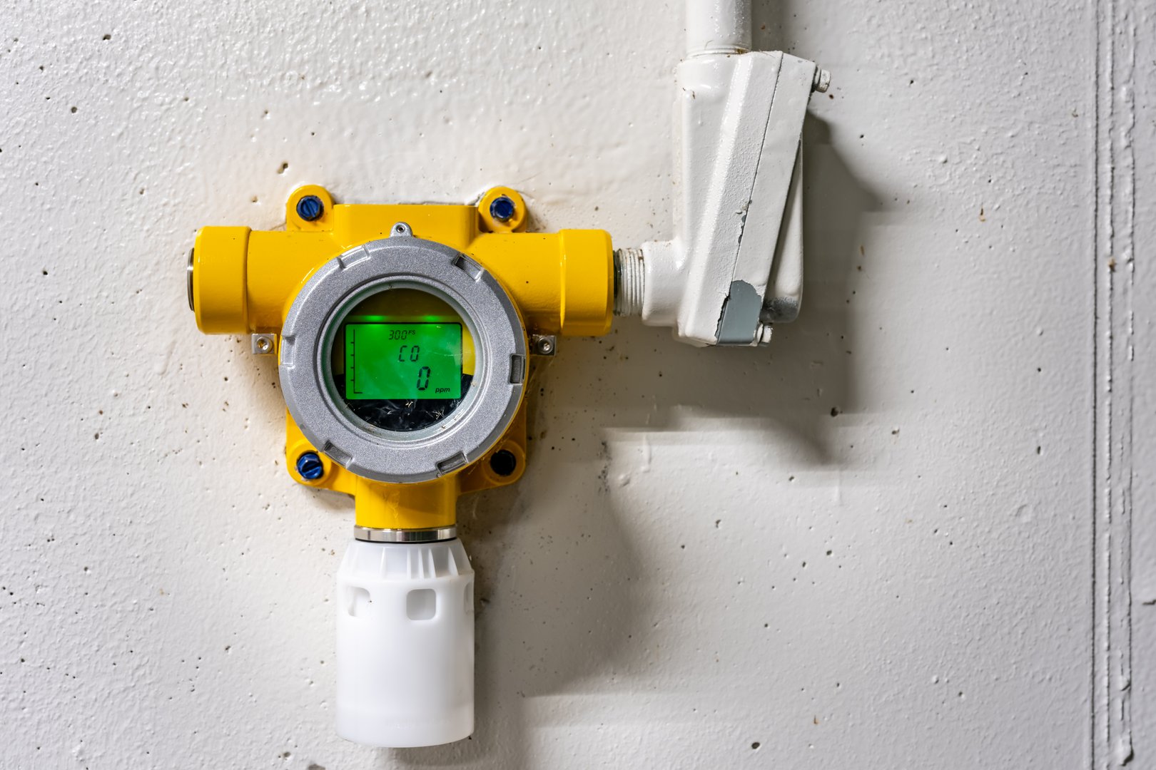 Yellow wall mounted industrial carbon monoxide gas monitoring detector, device in an industrial waste water treatment environment.