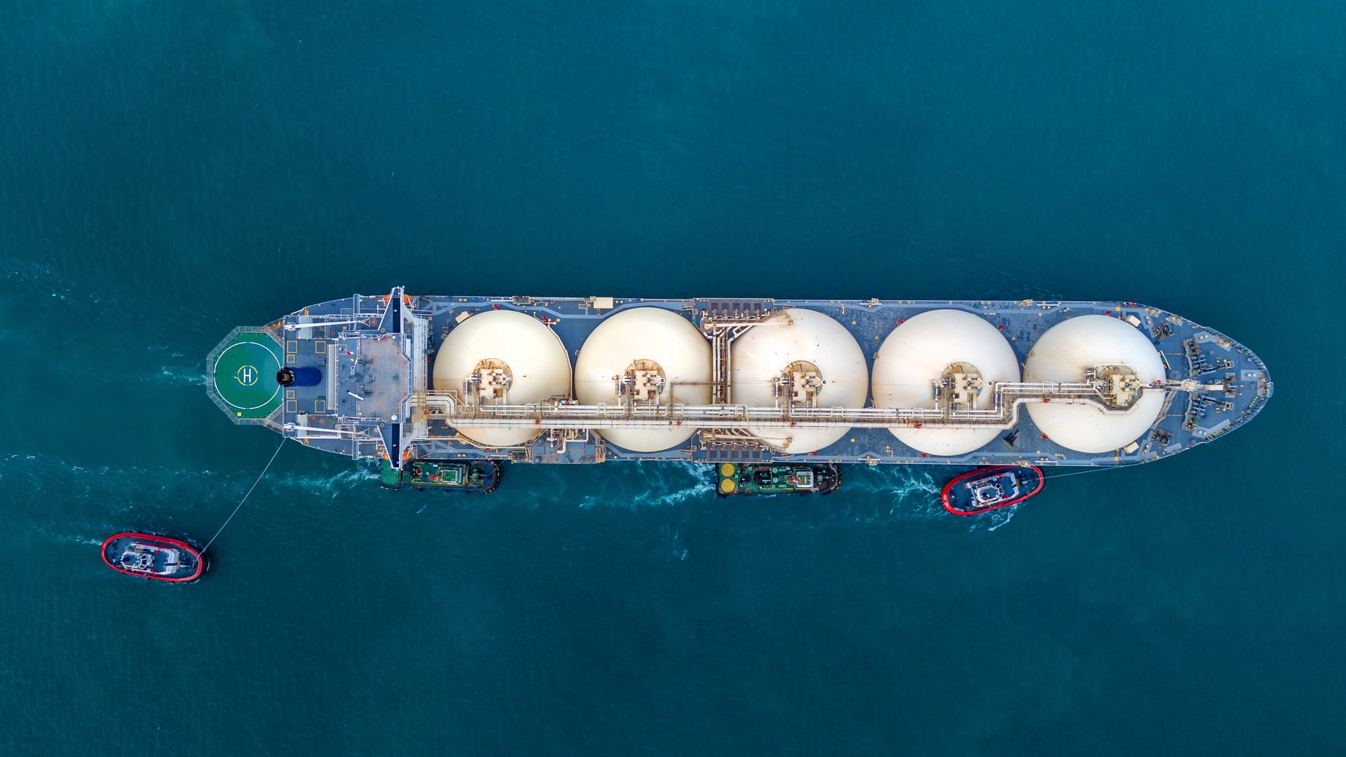 LNG (Liquified Natural Gas) tanker anchored in Gas terminal gas tanks for storage. Oil Crude Gas Tanker Ship. LPG at Tanker Bay Petroleum Chemical or Methane freighter export import transportation