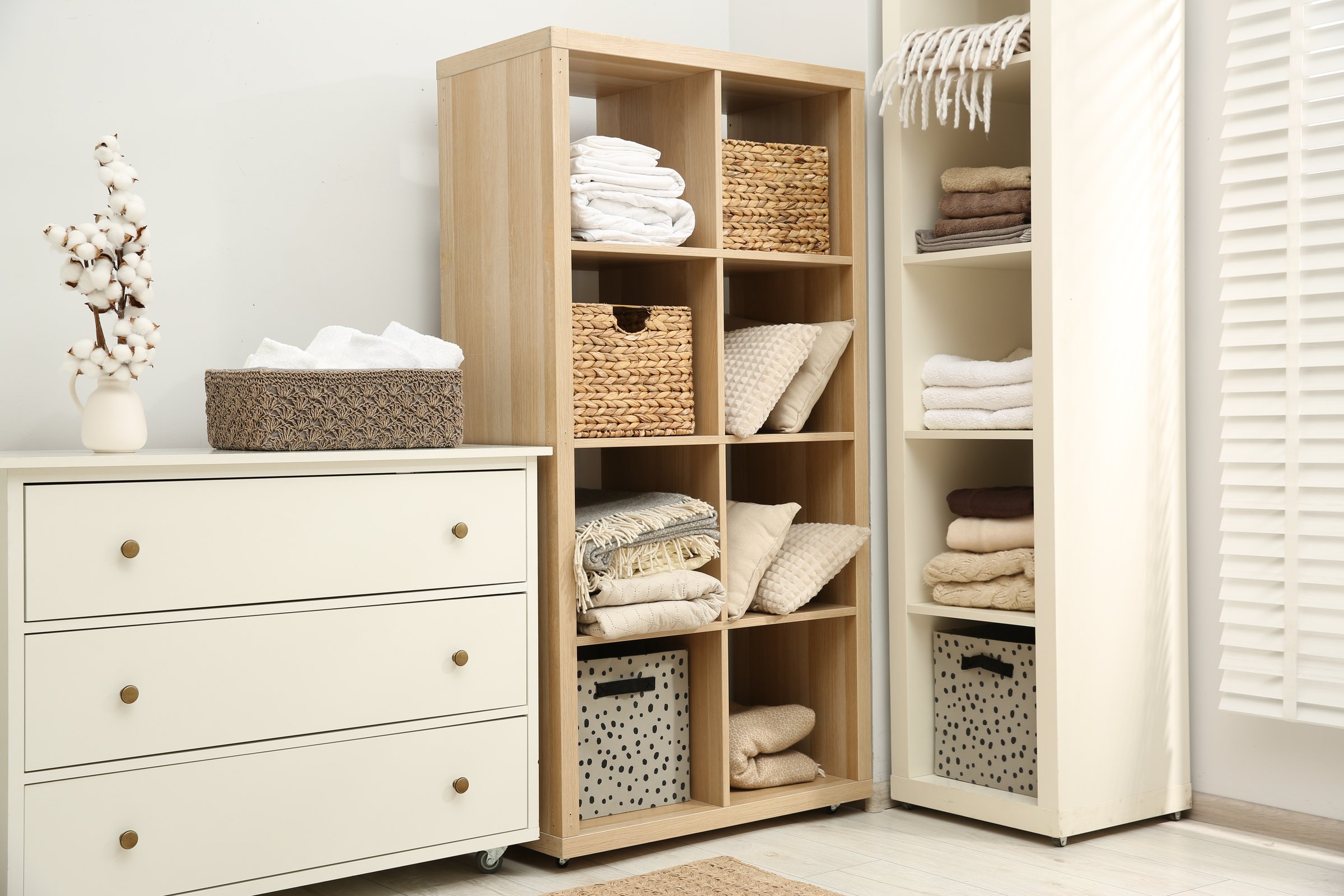 Home textile organization. Folded towels, blankets and pillows on shelving units indoors