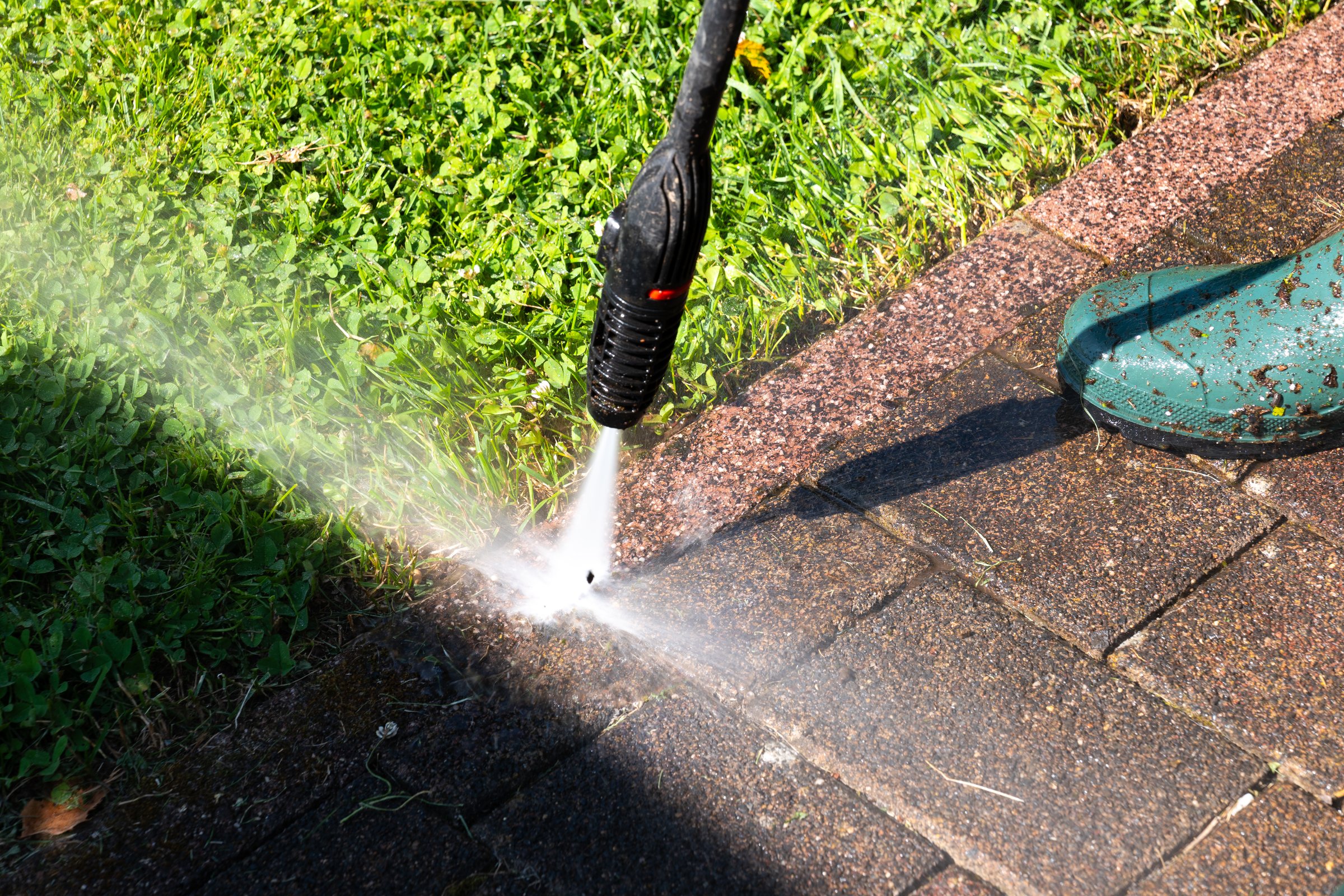 Close -up of cleaning dirty terrace with pressure washer. Visible before-and-after effect when pressure cleaning paving stones
