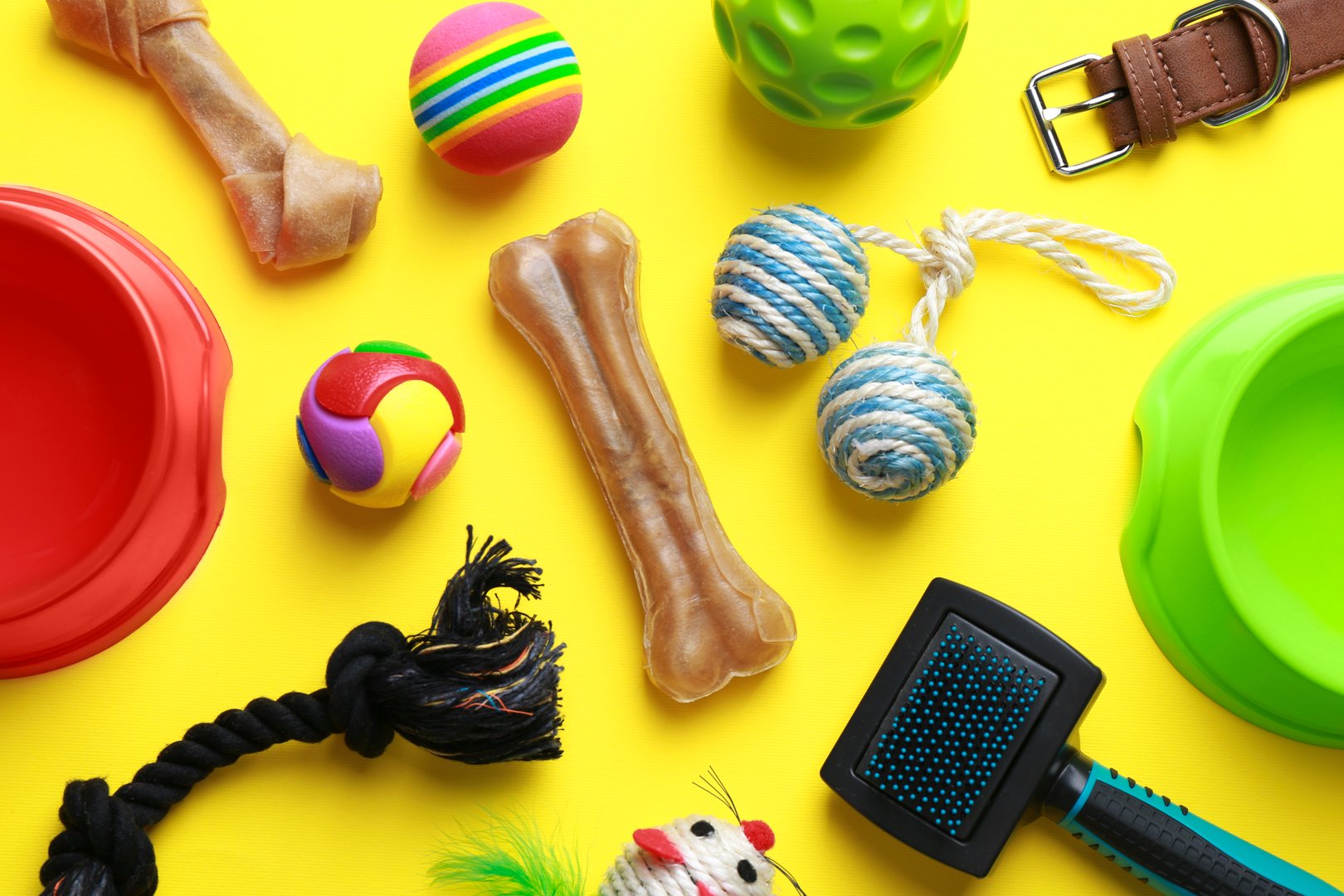 Flat lay composition with pet toys and feeding bowls on yellow background
