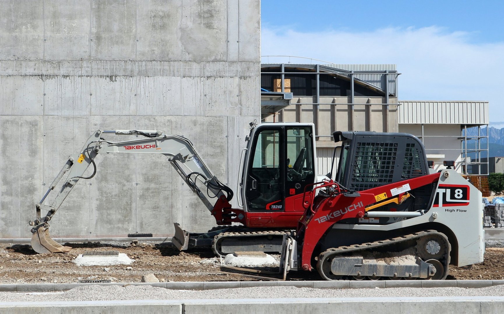 Udine, Italy. May  17, 2020. Brand new Takeuchi mini excavator and mini bulldozer at work in a construction site during a redevelopment of an industrial area