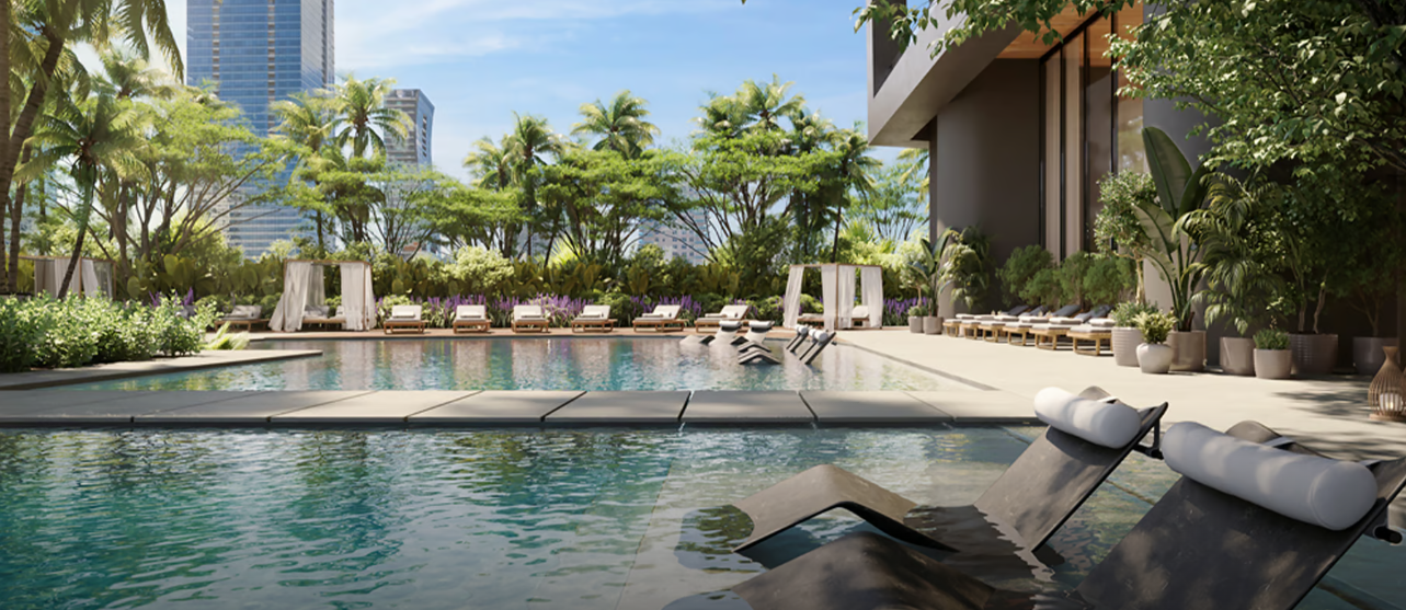 Luxurious outdoor pool area with lounge chairs, cabanas, and tropical plants, set against a city skyline background.