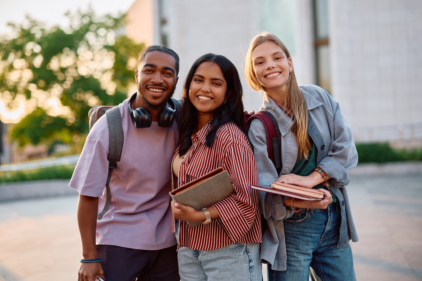 Multiracial group of happy college friends outdoors looking at camera.