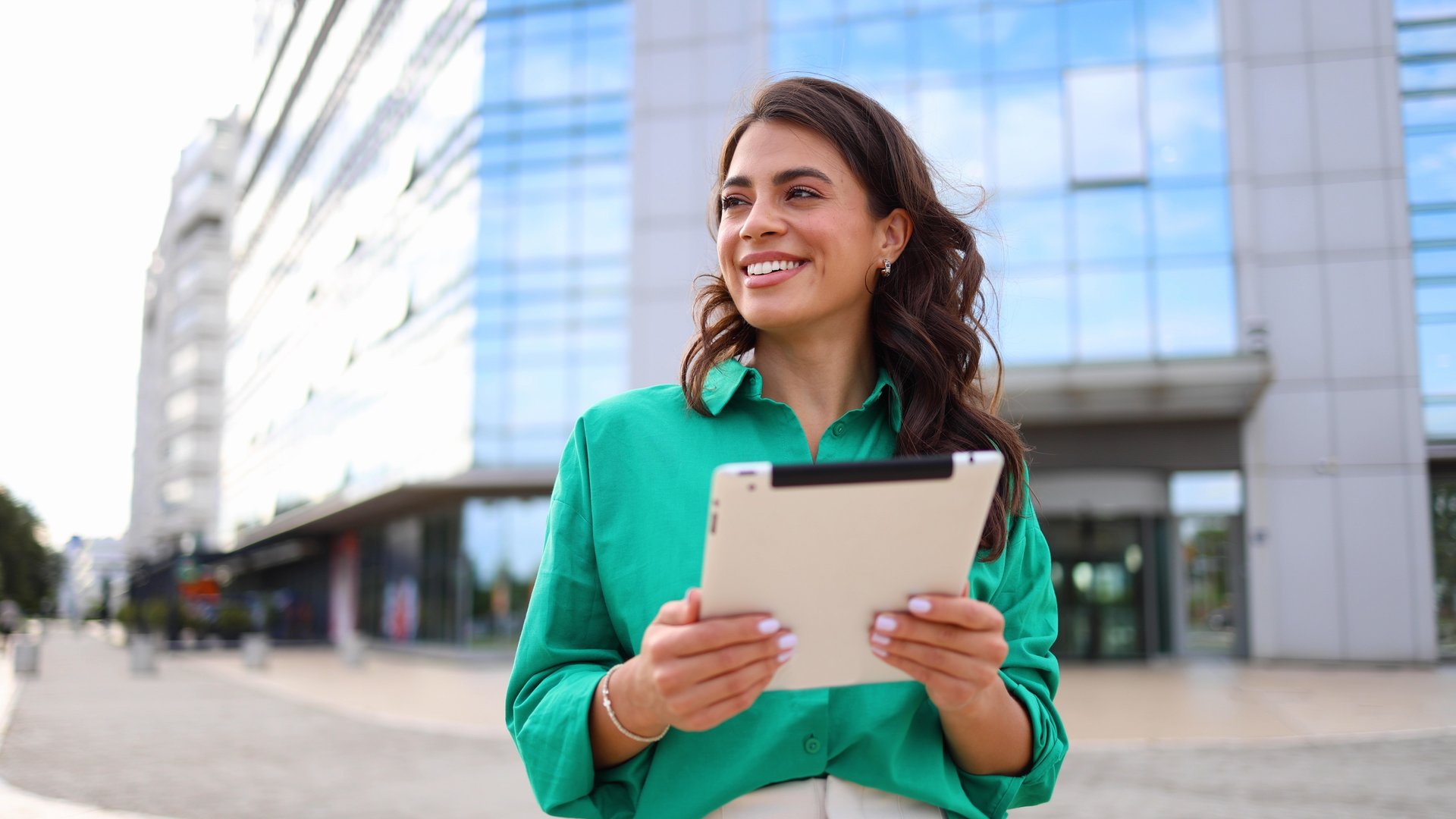 Happy businesswoman using tablet in the city
