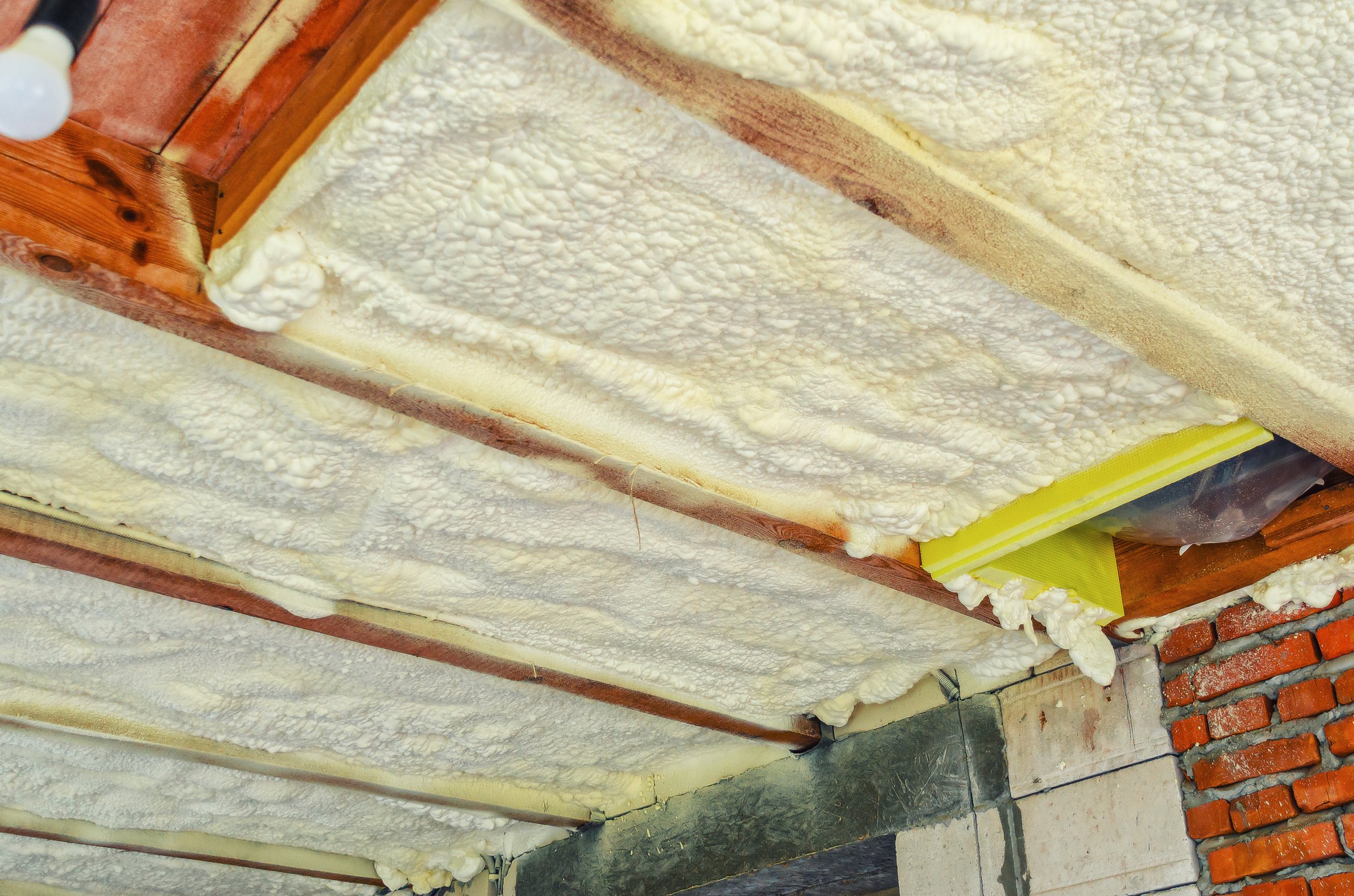 Insulation of the ceiling in the house with polyurethane foam. Insulating foam between wooden beams