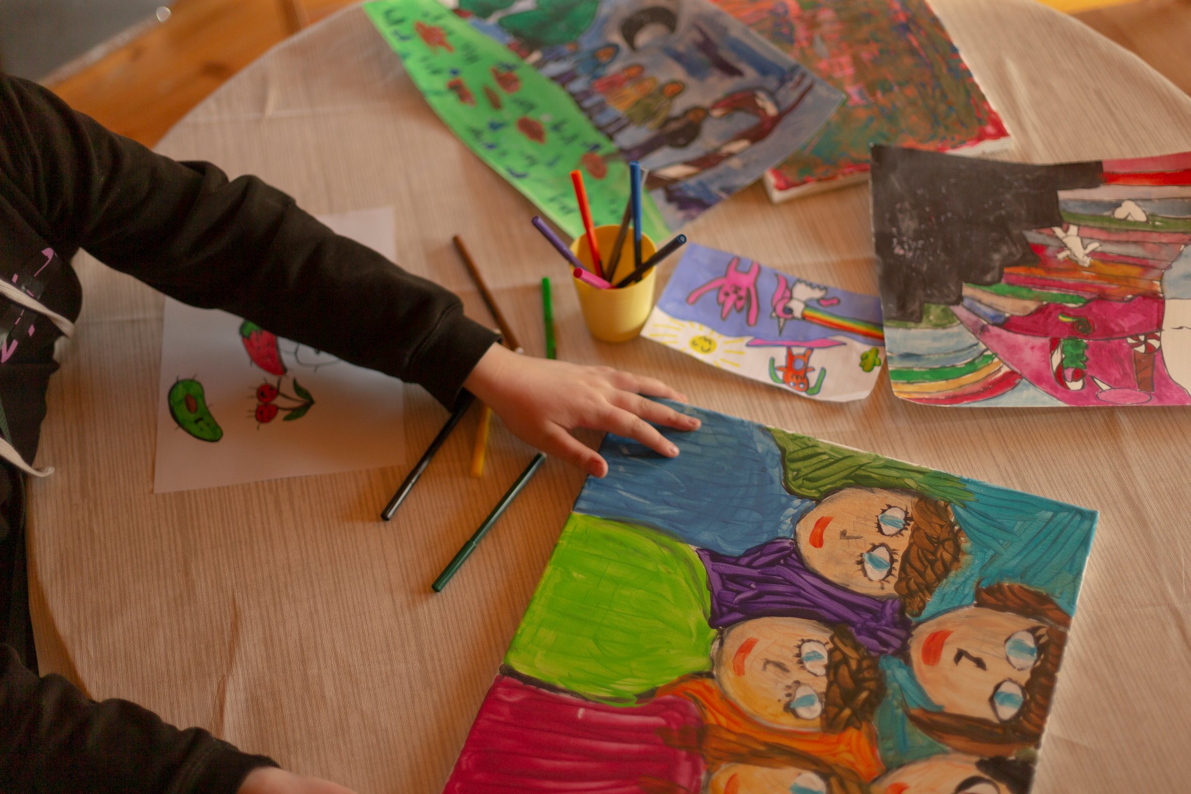 Self-expression in art. Teenage girl painted bright, colorful portrait of her large family, parents and four siblings. Expressive artwork reflects love, creativity, and pride she feels in family bonds