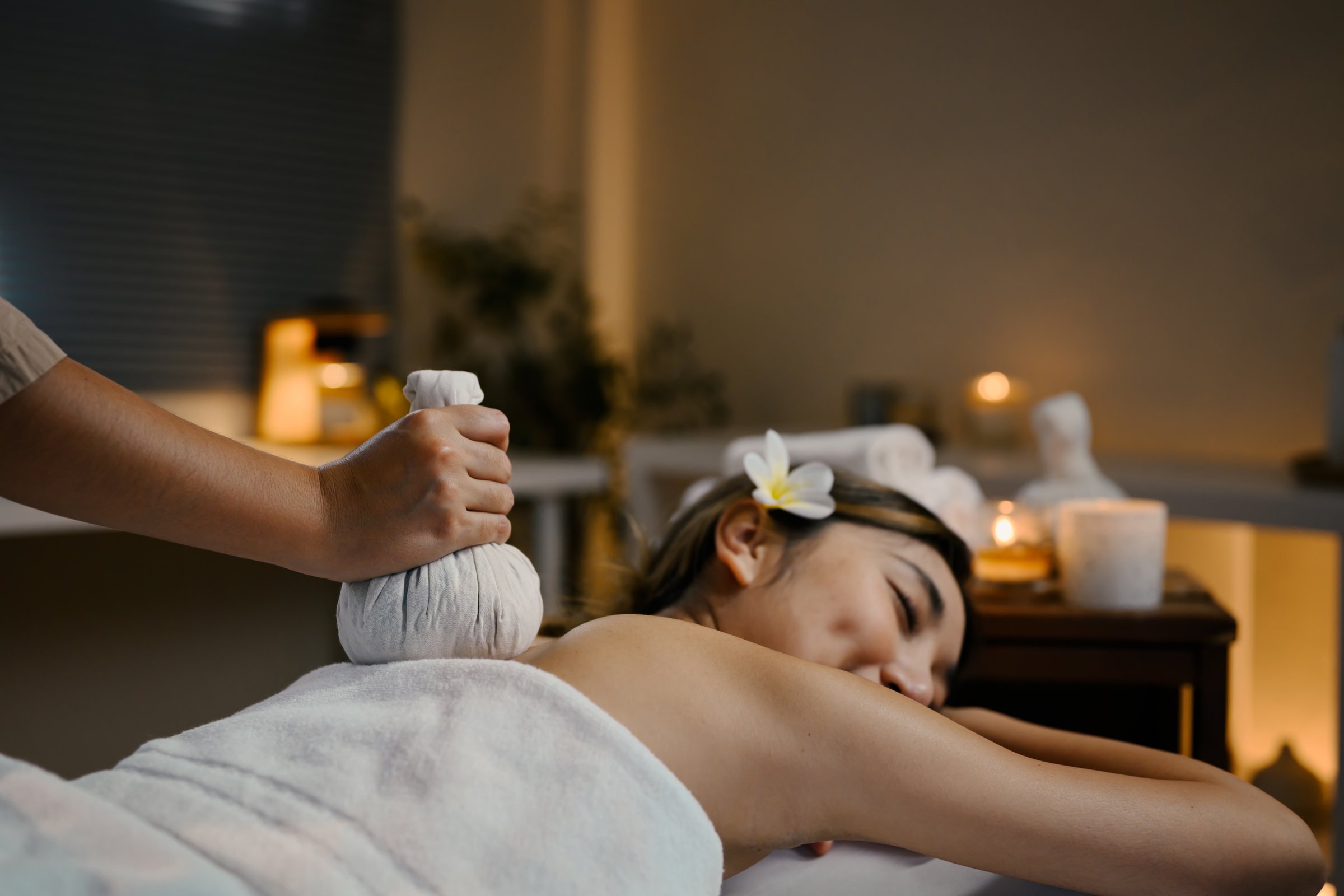 Close up of herbal compress massage on woman back in spa. Well ness concept.