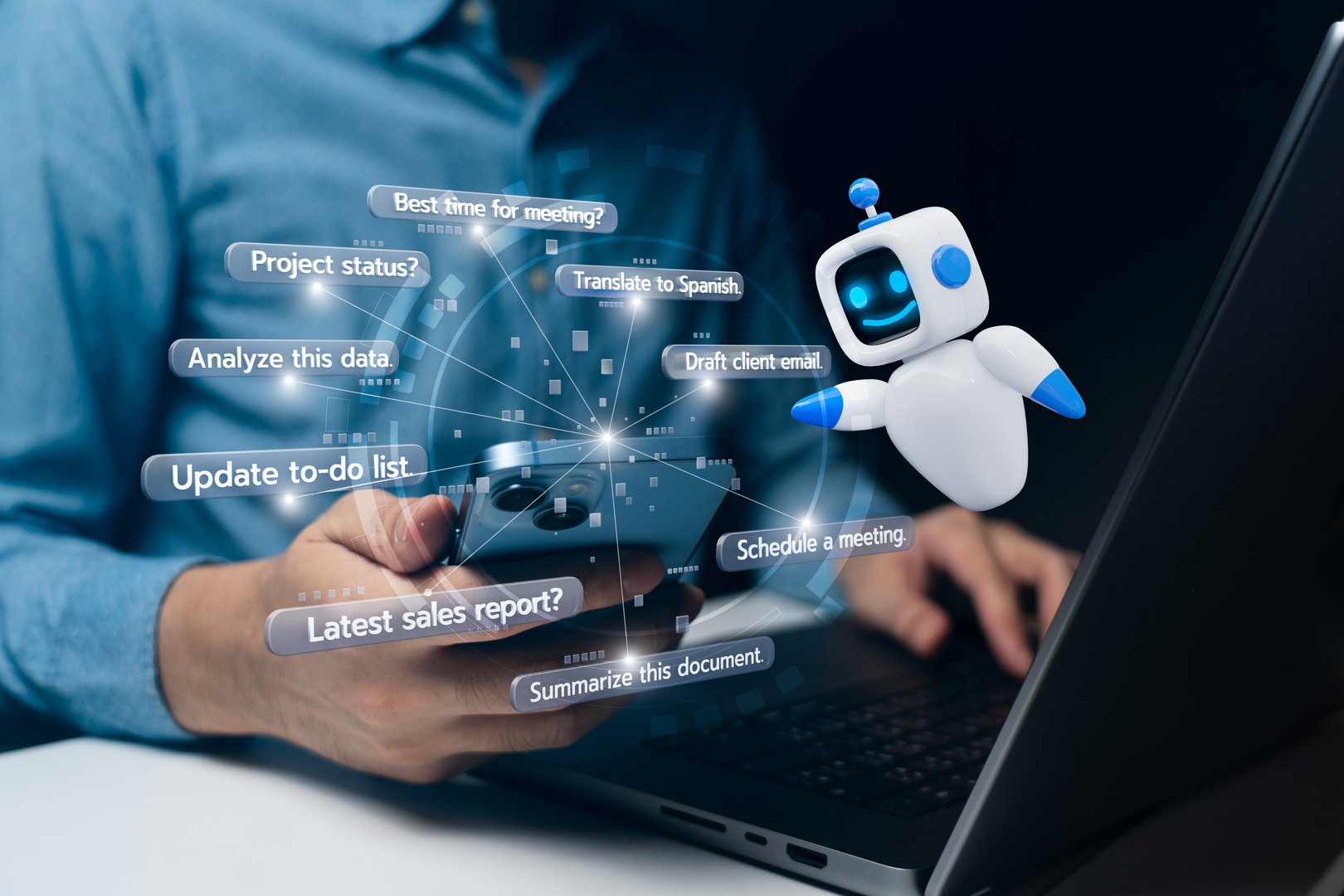A person using a smartphone to interact with an AI assistant displayed as a friendly robot and chat bubbles. The background shows a laptop indicating multitasking and technology use.