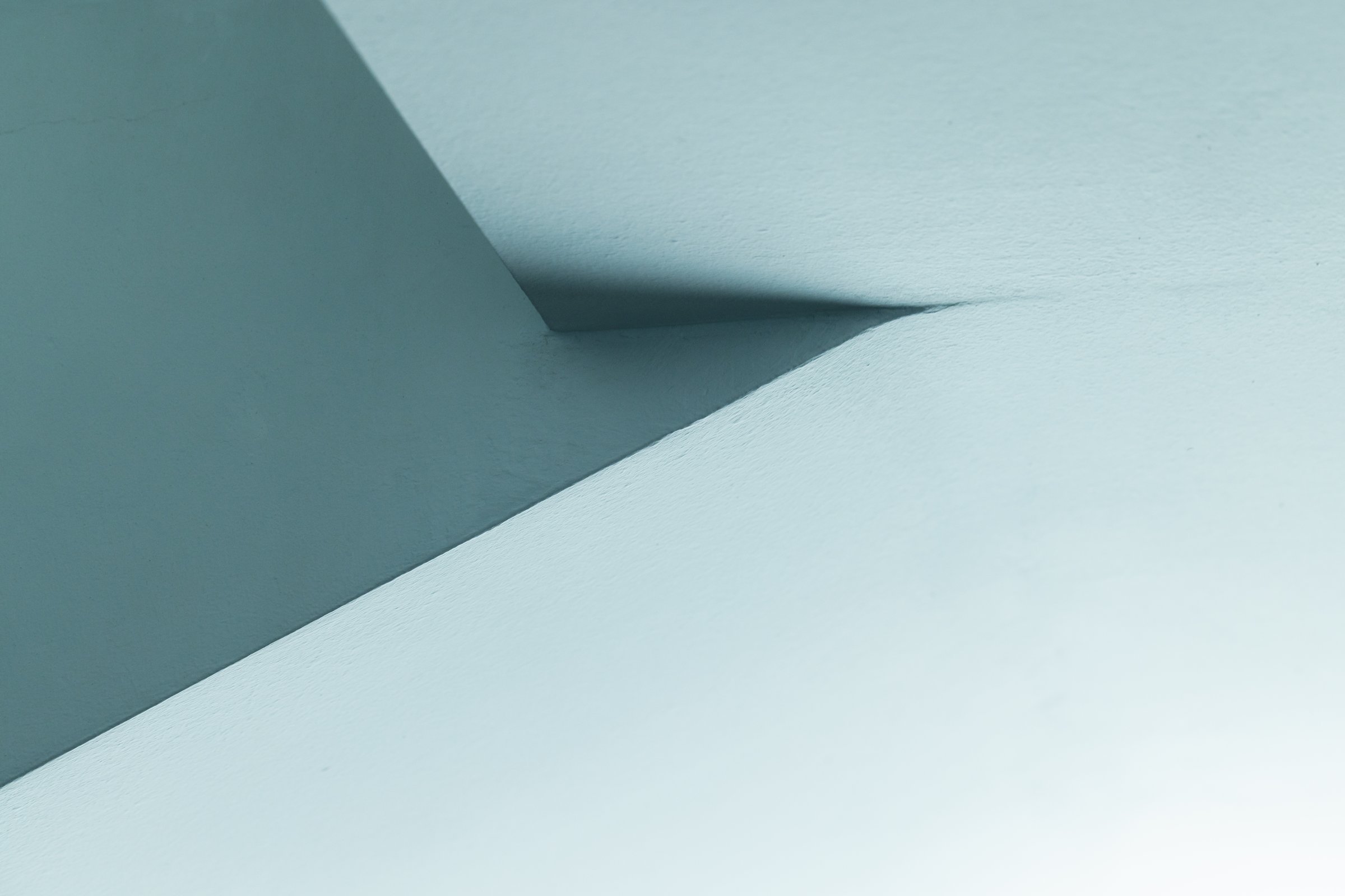 Abstract image showcasing minimalist architectural design with smooth surfaces, sharp angles, and soft blue tones, highlighting the beauty of simplicity and structure in a creative and artistic way