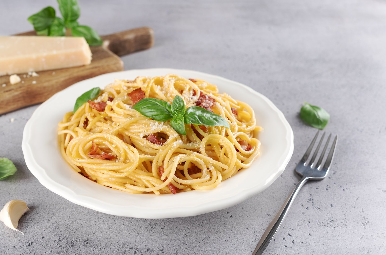 Italian pasta carbonara with ingredients on gray background. Homemade carbonara recipe for food blogs, menus, books