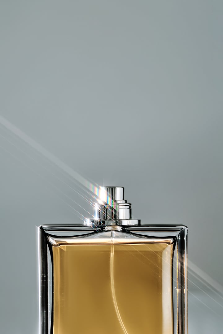 A bottle of yellow perfume with a beautiful highlight. High quality photo.