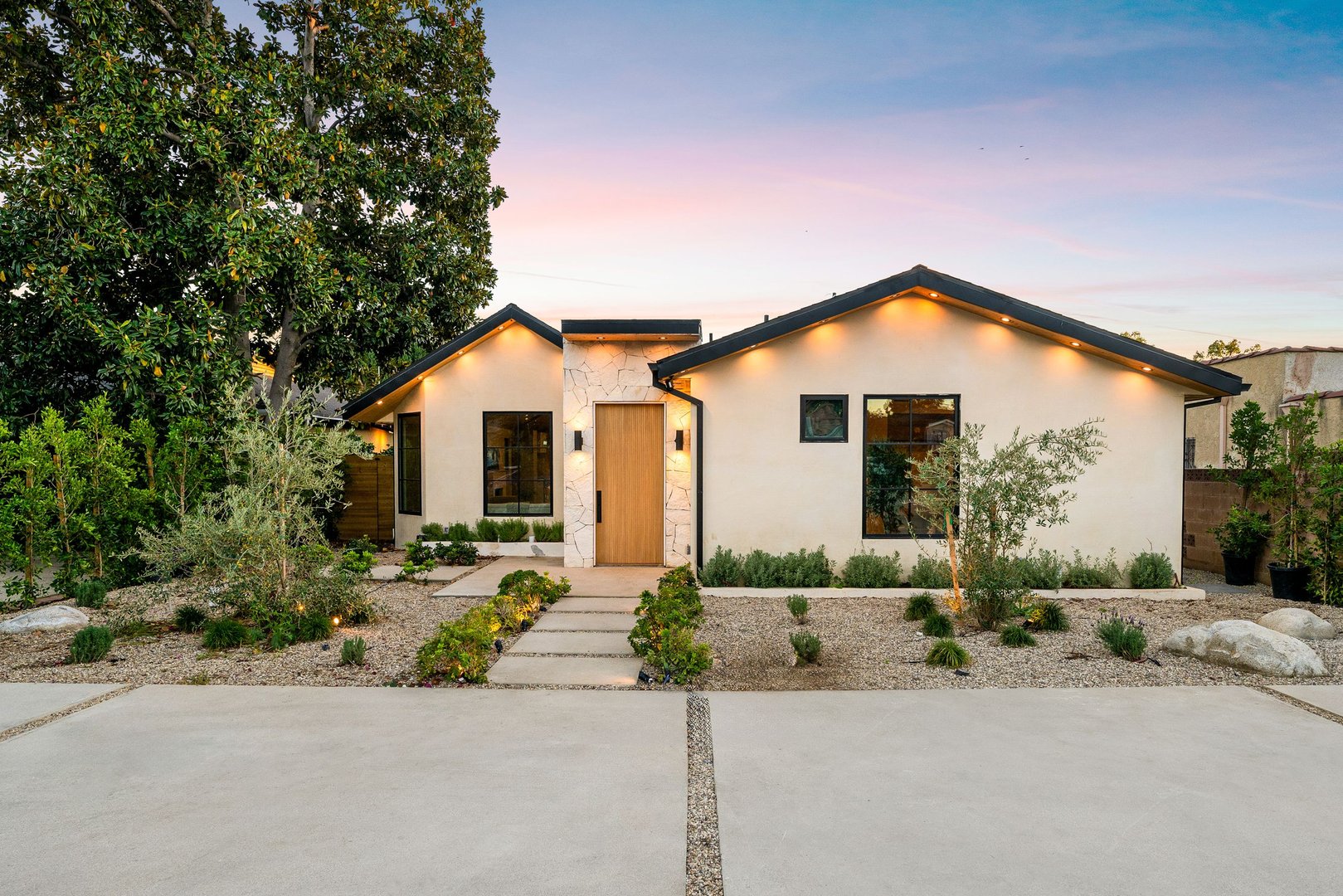 Modern single-story home exterior with minimalist landscaping at sunset.