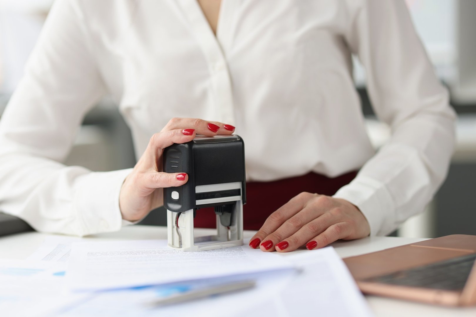 Businesswoman puts stamp on credit documents at work desk. Small and medium business development concept