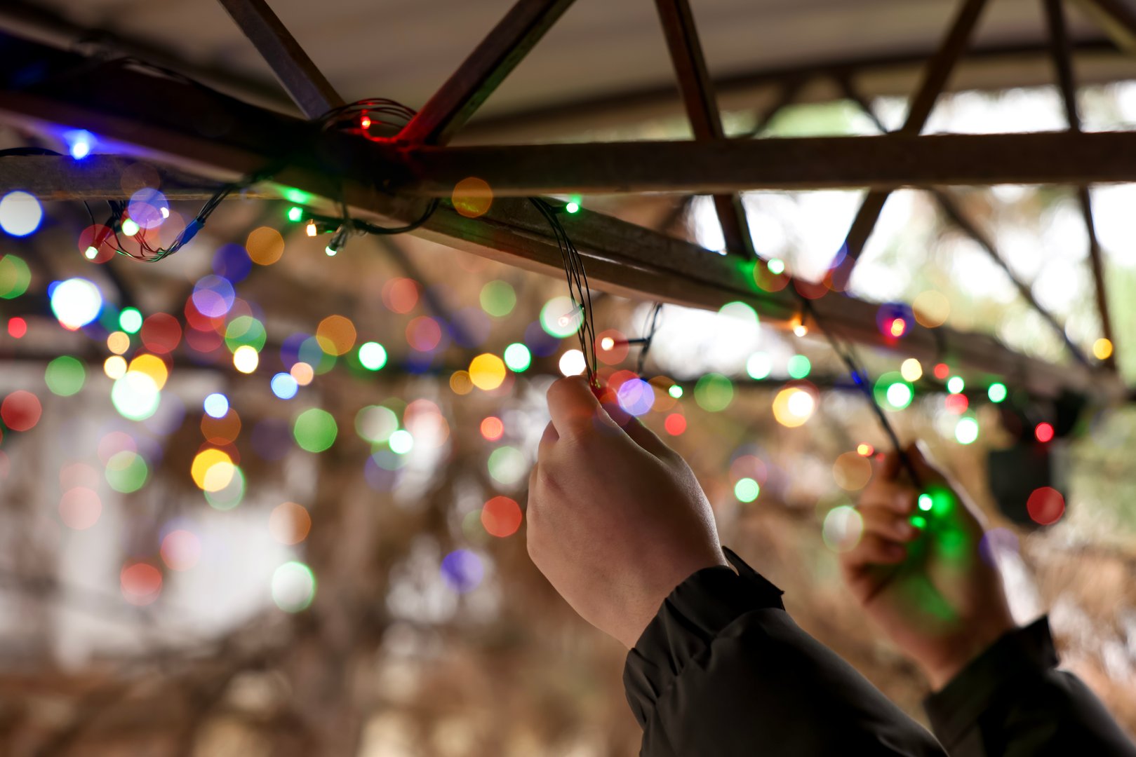Man decorating house with Christmas lights