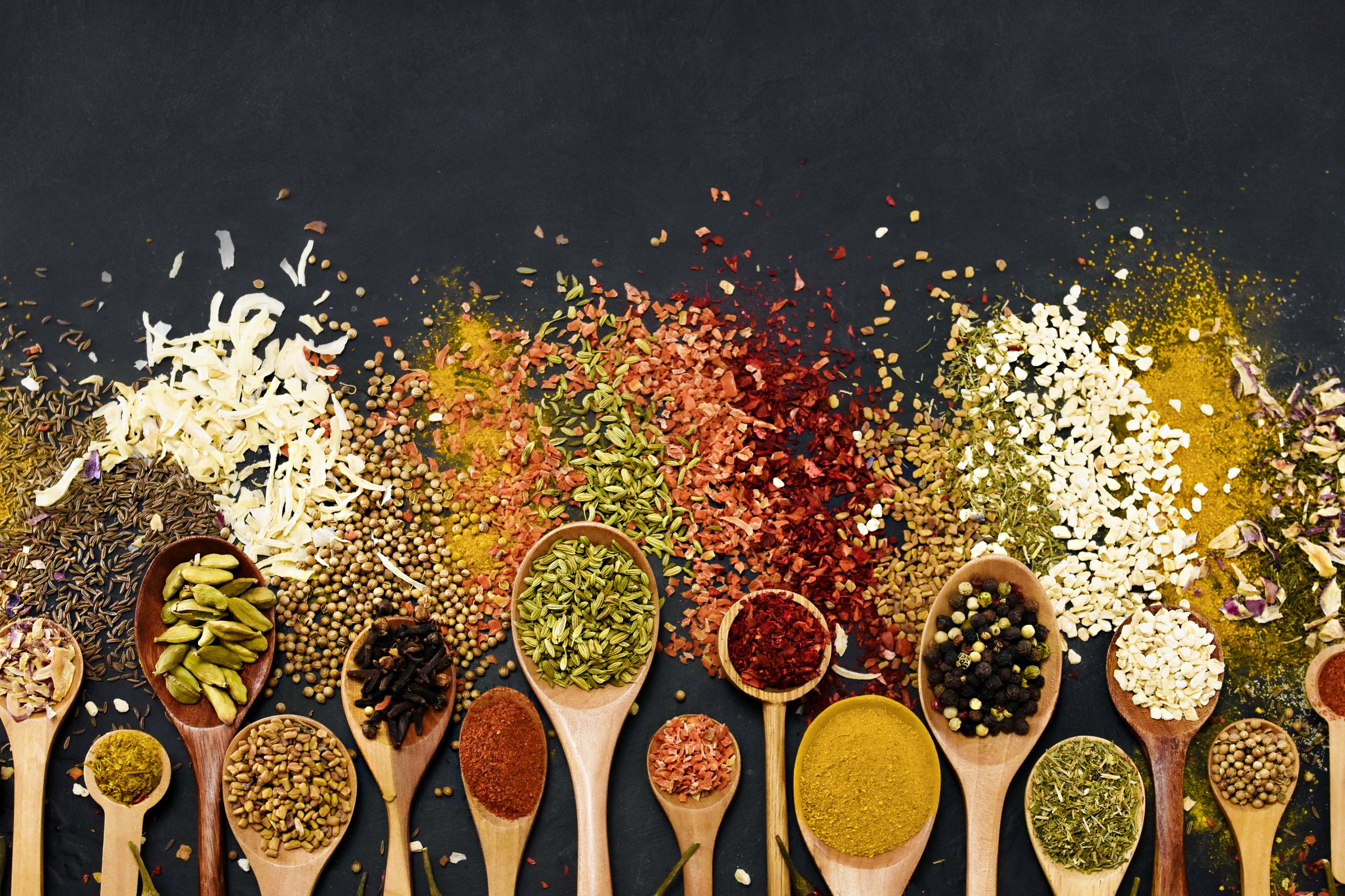 Colorful mix of herb and spice varieties: curry and coriander, turmeric and cumin, paprika and pepper, mustard and salt, cardamon and oregano and saffron. Food ingredients background