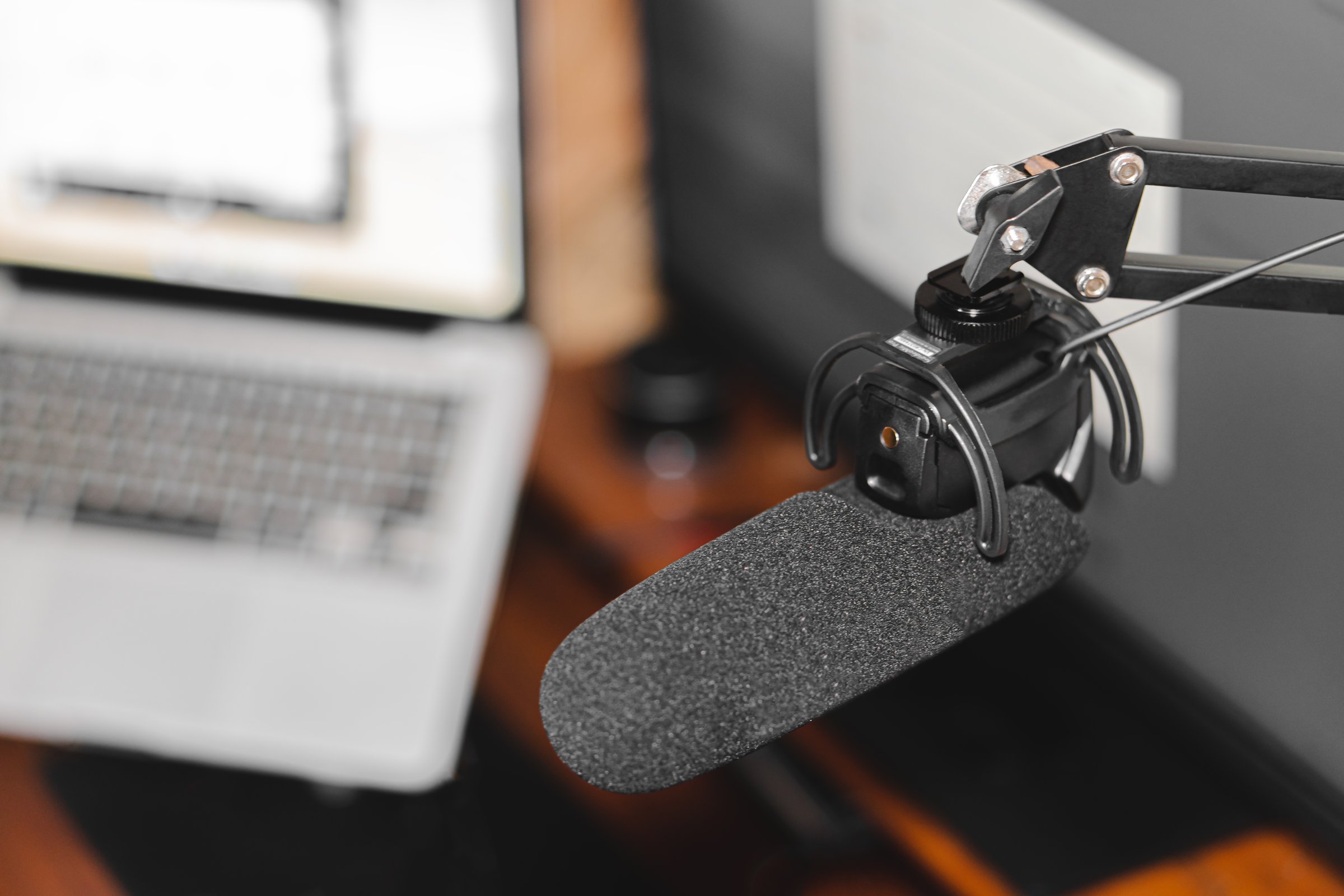 Home studio podcast interior. Microphone, laptop and on air lamp on the table, close-up