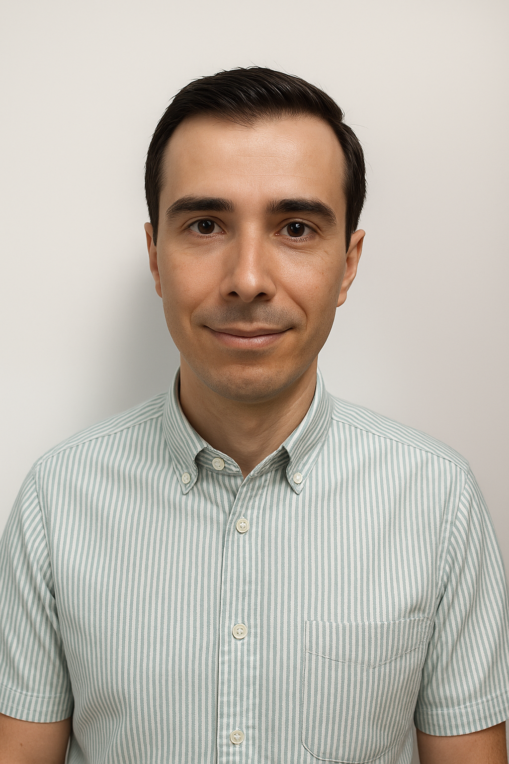 Man in a green-striped shirt, short dark hair, standing against a plain white background, facing forward.