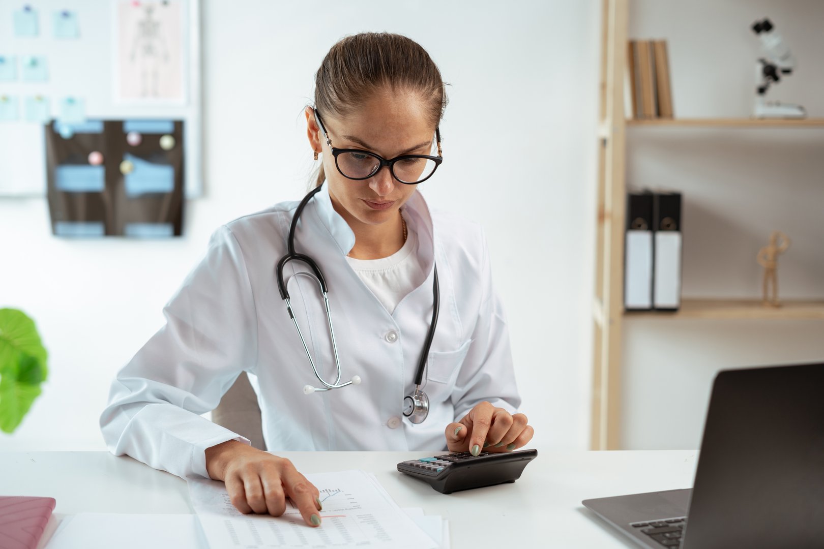Female doctor calculating medical costs and revenue