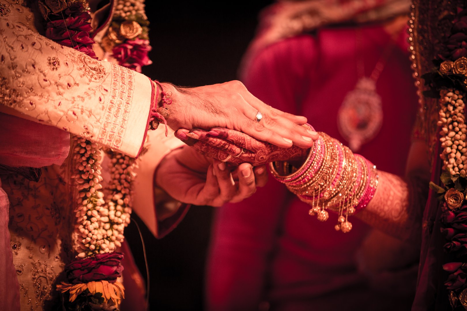 Closeup of indian wedding couple holding hands.