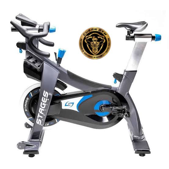 A modern exercise bike with a sleek design and blue accents, positioned next to a Cuban Gym II logo featuring a bull.