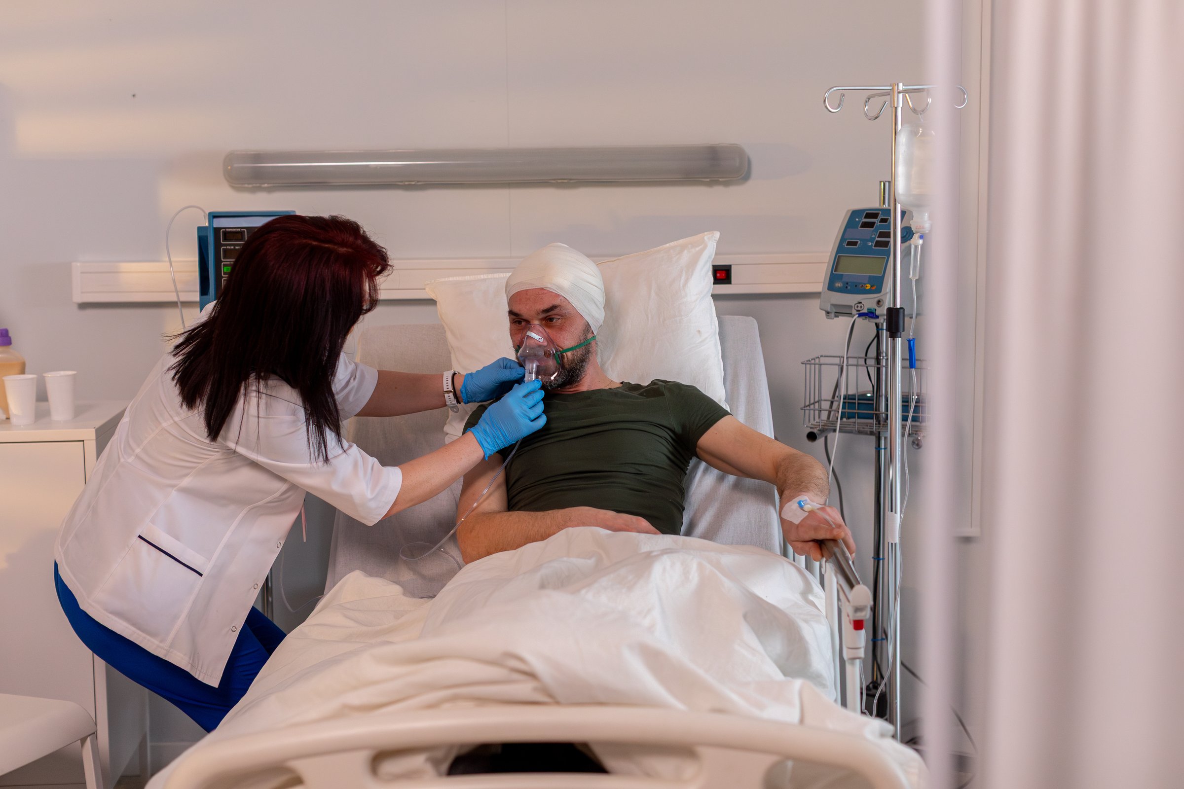 A dedicated nurse compassionately cares for a patient with a serious head injury in a hospital room